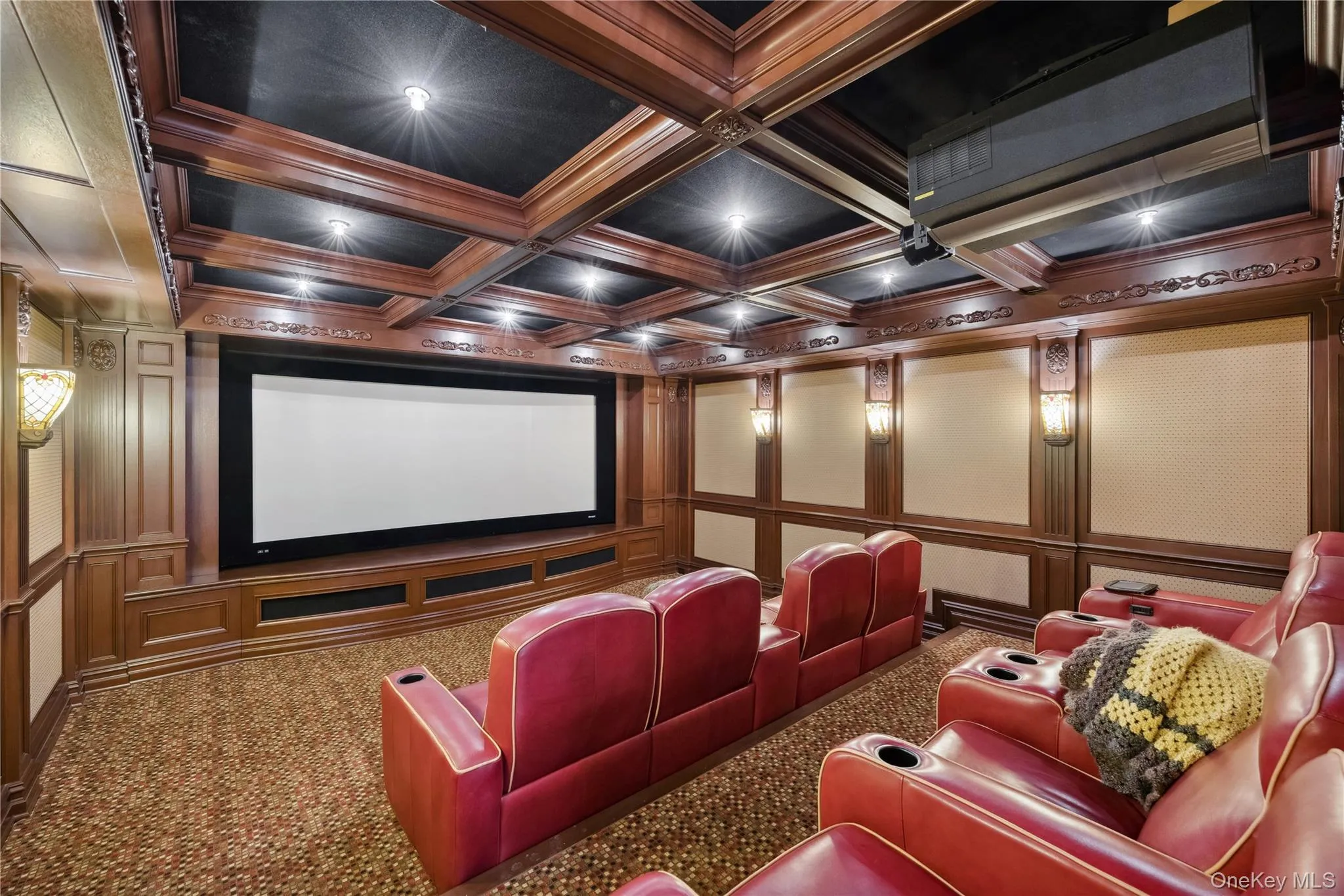 Carpeted cinema room with a decorative wall, coffered ceiling, ornamental molding, and beamed ceiling Carpeted cinema room with a decorative wall, coffered ceiling, ornamental molding, and beamed ceiling