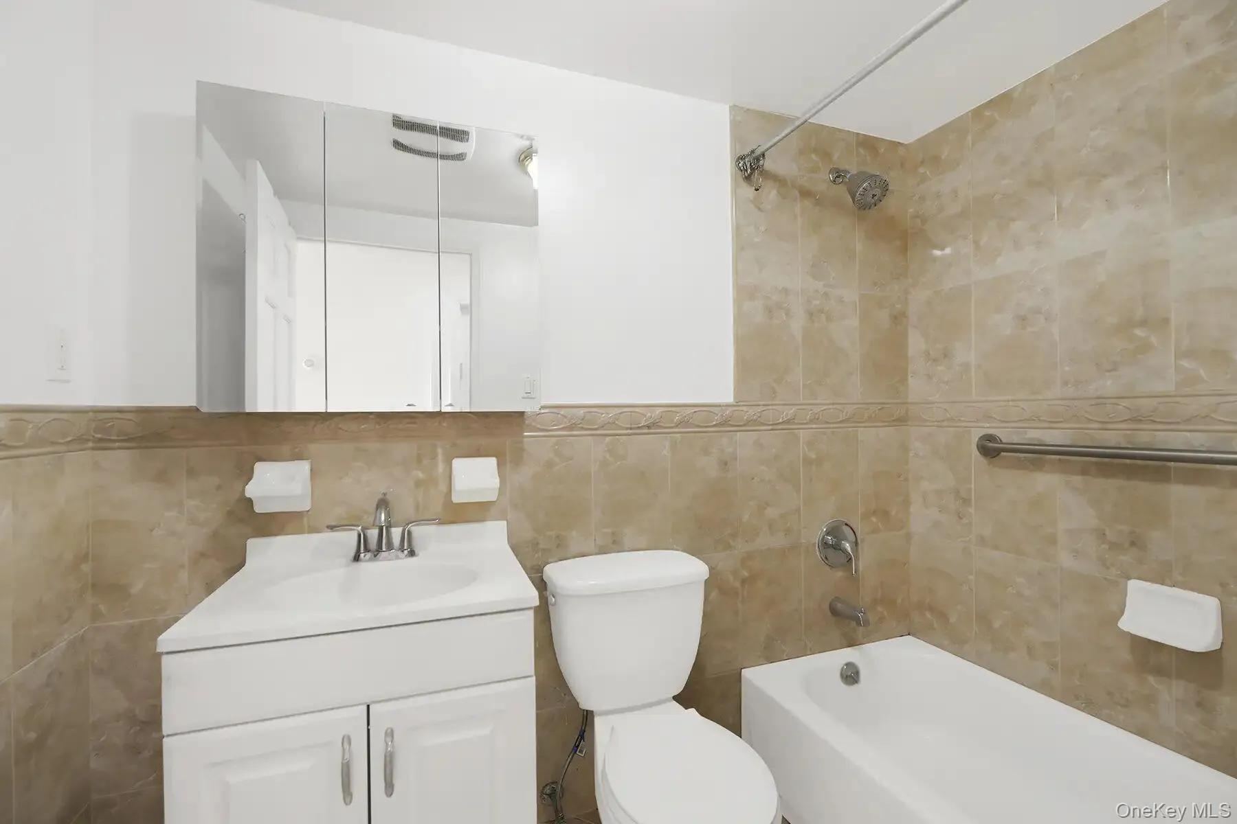 Full bathroom with tub / shower combination, vanity, and tile walls Full bathroom with tub / shower combination, vanity, and tile walls