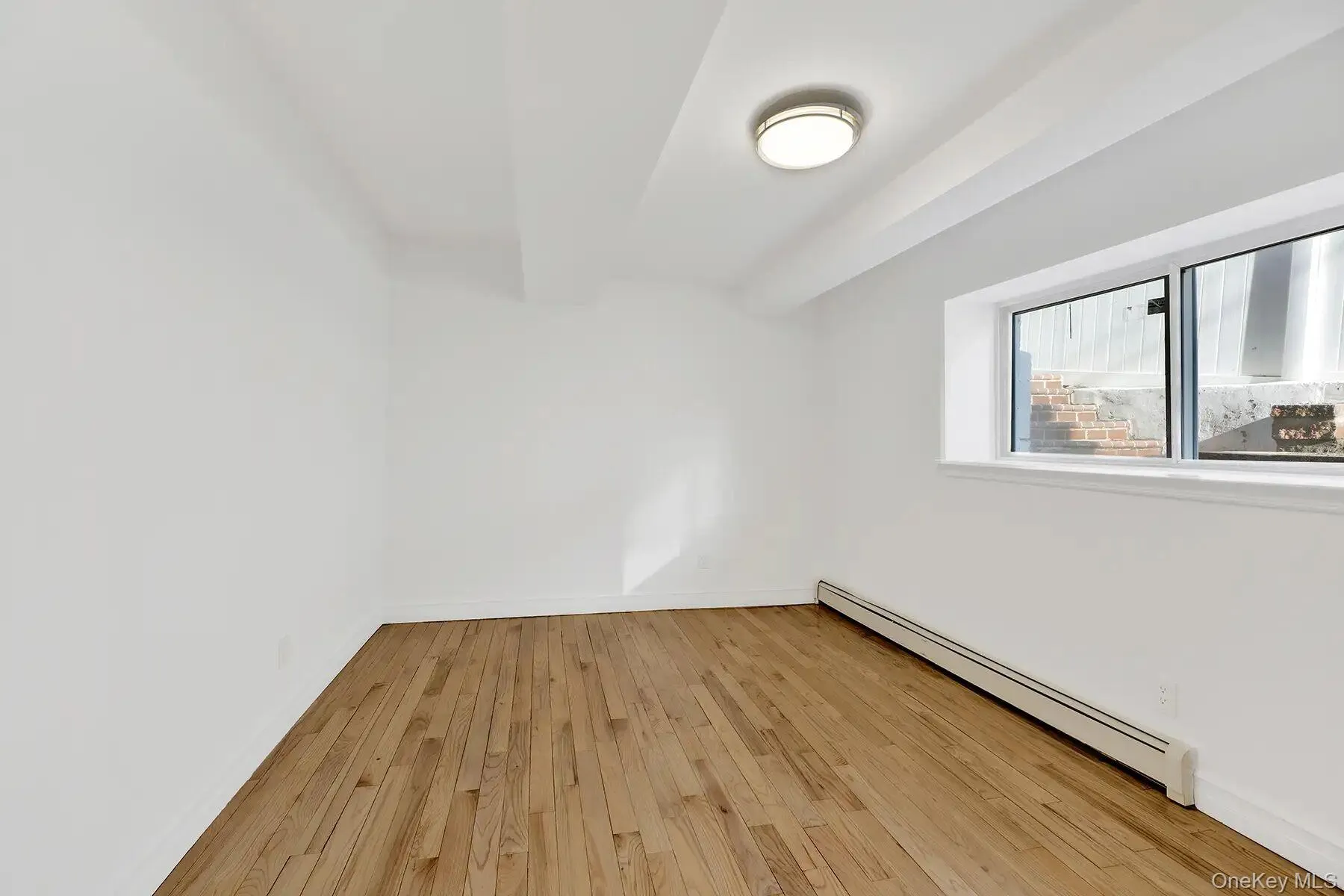 Spare room with a baseboard heating unit and light wood-style flooring Spare room with a baseboard heating unit and light wood-style flooring