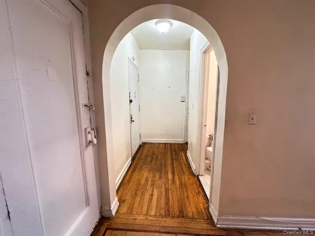 Hall featuring hardwood / wood-style floors and arched walkways Hall featuring hardwood / wood-style floors and arched walkways