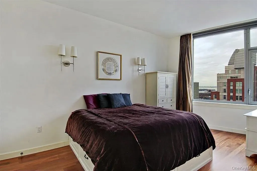 Bedroom featuring wood finished floors and baseboards Bedroom featuring wood finished floors and baseboards