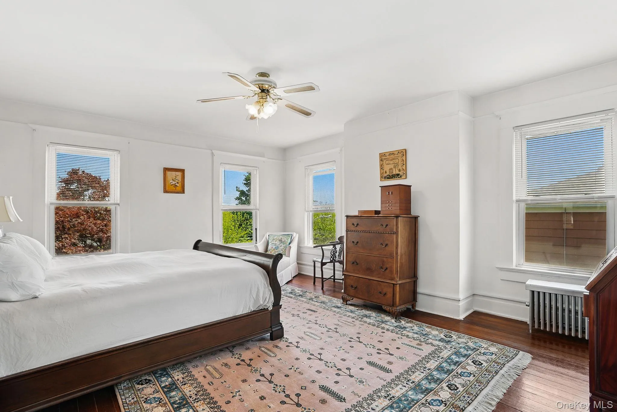 Corner primary bedroom with hardwood floors Corner primary bedroom with hardwood floors