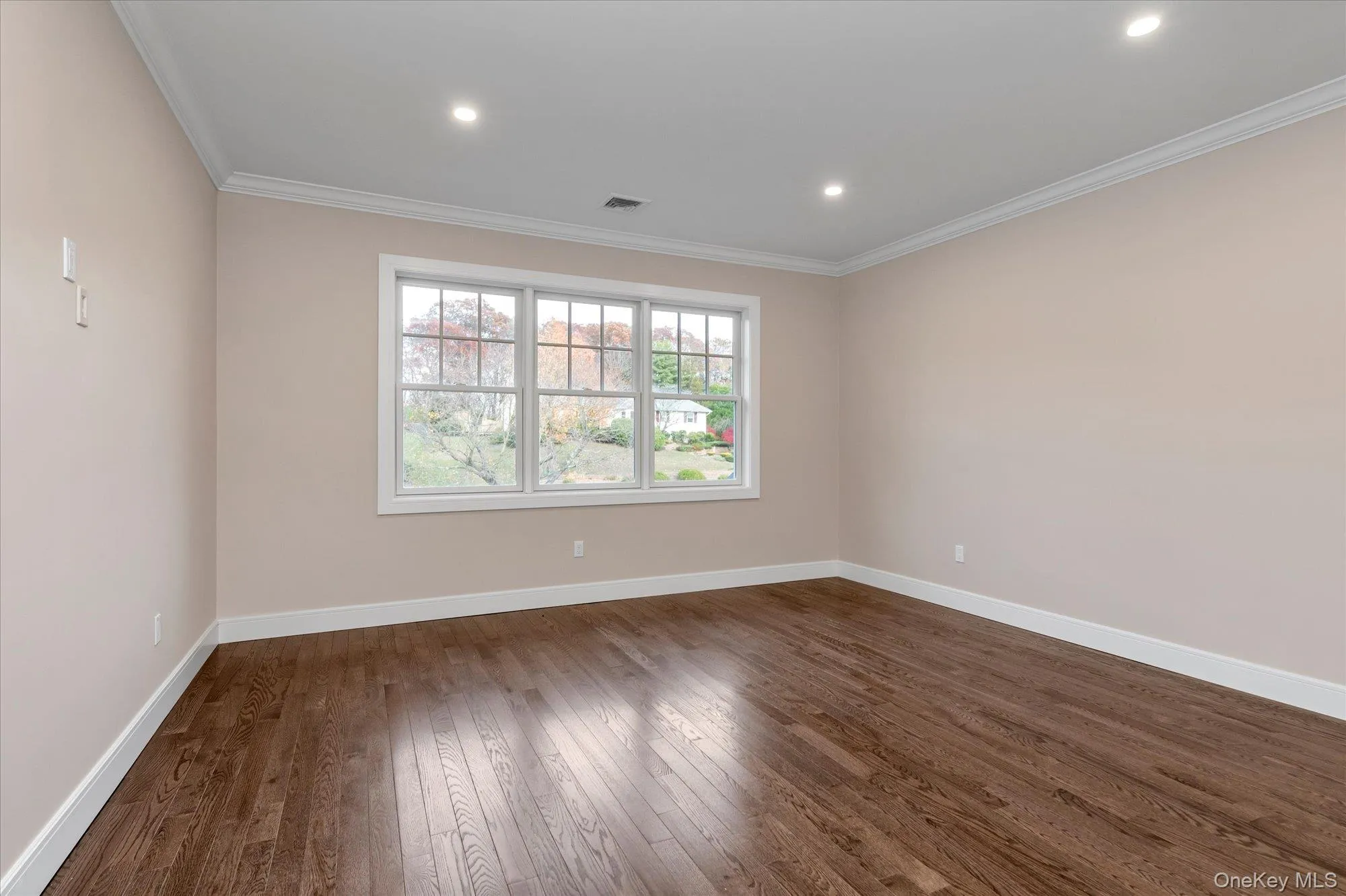 Spare room featuring dark wood-type flooring, crown molding, and recessed lighting Spare room featuring dark wood-type flooring, crown molding, and recessed lighting