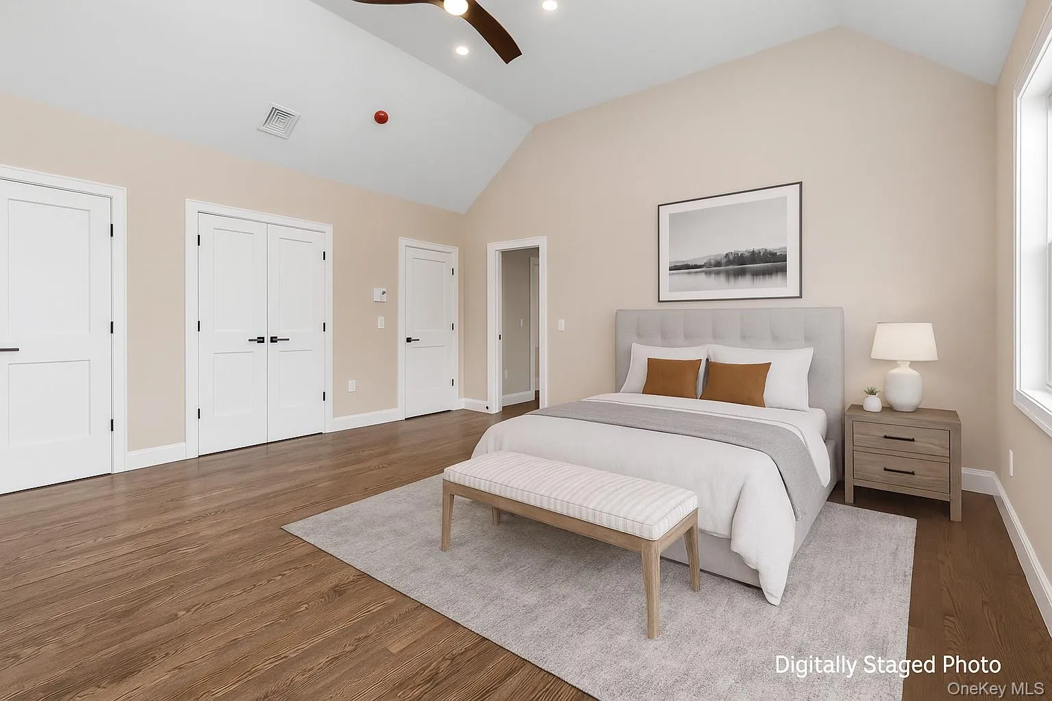Bedroom with lofted ceiling, wood finished floors, a ceiling fan, and multiple closets Bedroom with lofted ceiling, wood finished floors, a ceiling fan, and multiple closets
