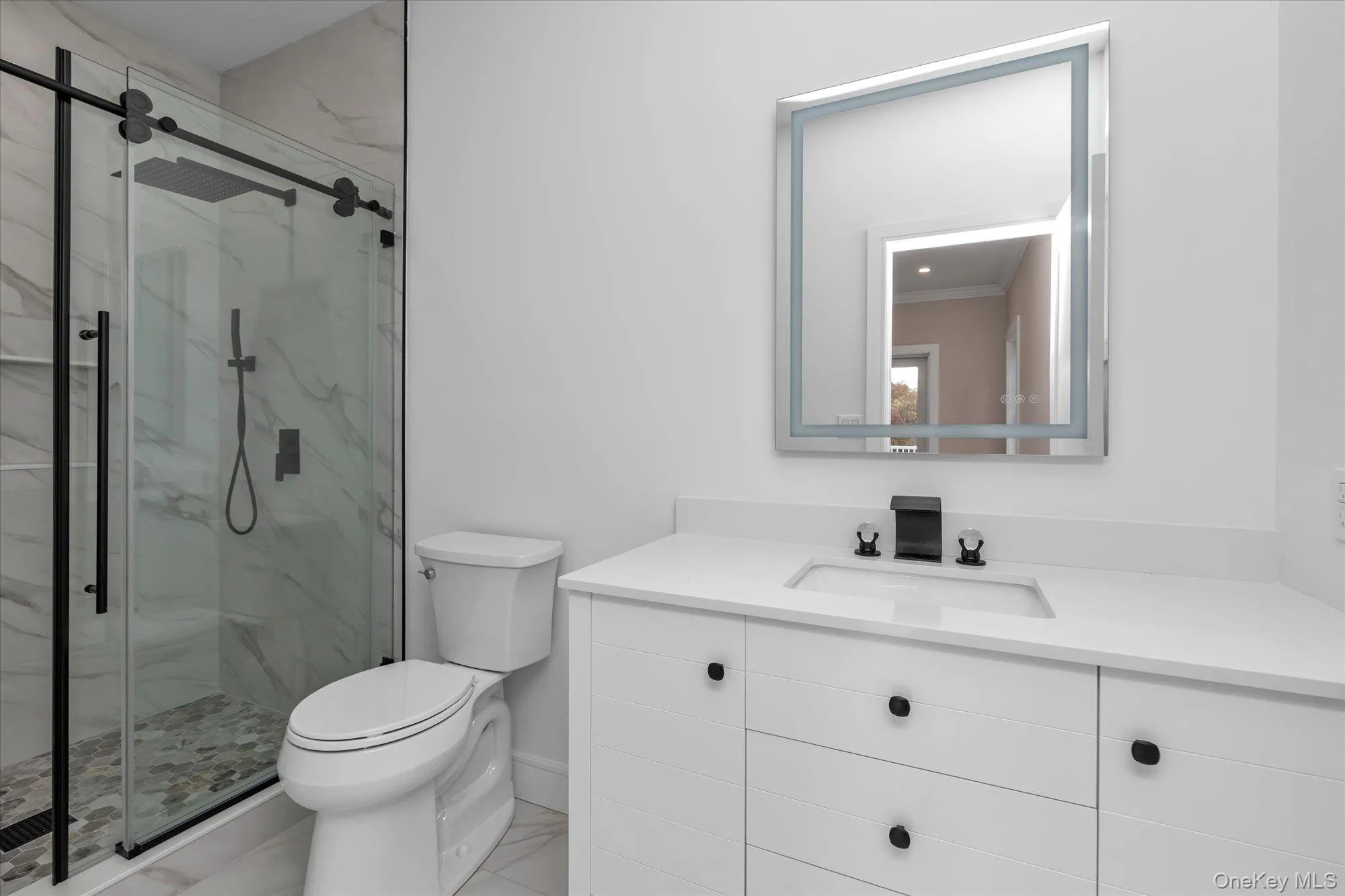 Full bath with vanity, a marble finish shower, and light marble finish floors Full bath with vanity, a marble finish shower, and light marble finish floors