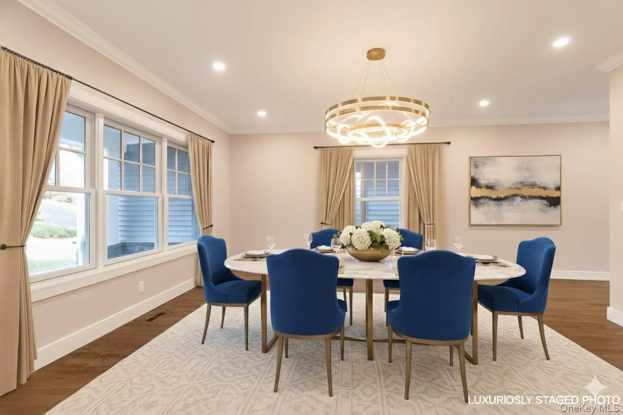 Dining space featuring dark wood finished floors, ornamental molding, a chandelier, and recessed lighting Dining space featuring dark wood finished floors, ornamental molding, a chandelier, and recessed lighting