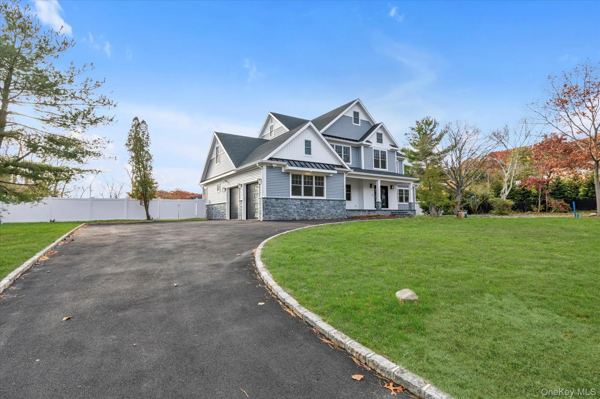 View of front of house featuring stone siding, driveway, and a porch View of front of house featuring stone siding, driveway, and a porch