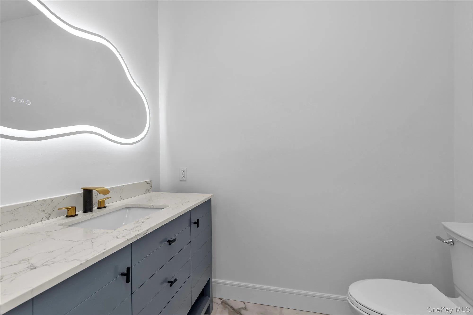 Half bath with vanity and light marble finish flooring Half bath with vanity and light marble finish flooring