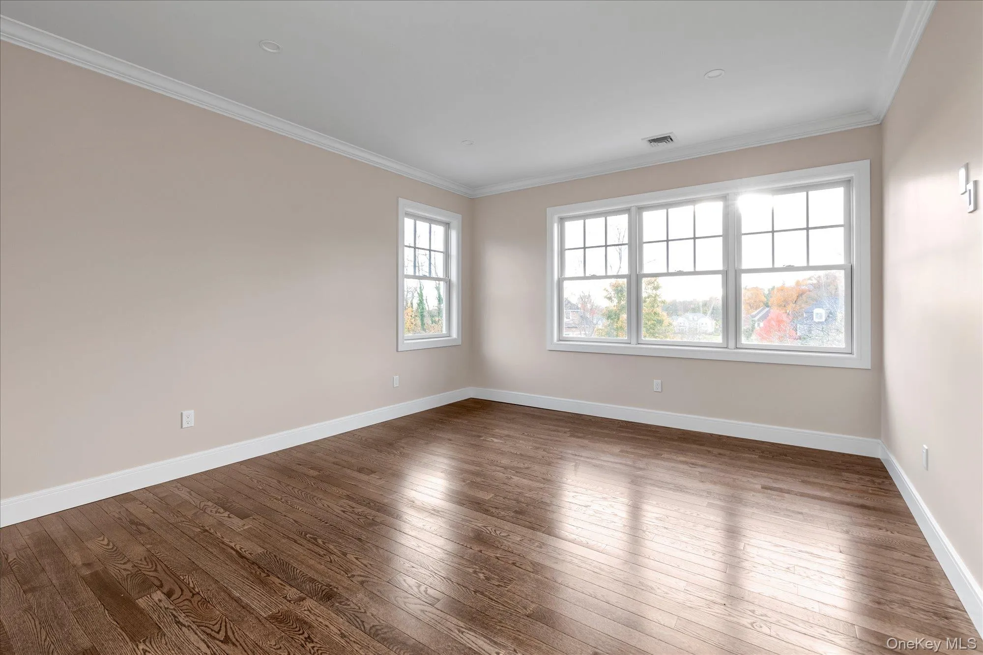 Spare room with crown molding and hardwood / wood-style floors Spare room with crown molding and hardwood / wood-style floors