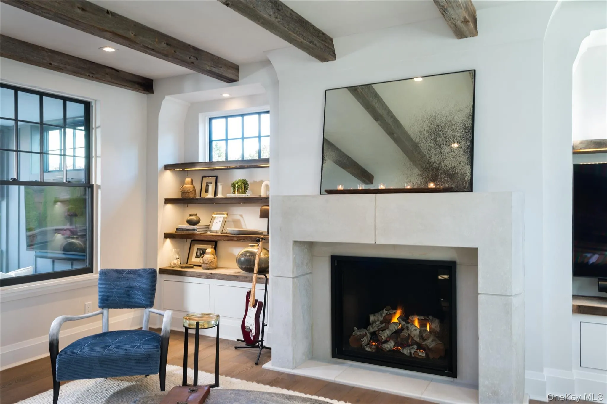 Living area with wood finished floors, recessed lighting, a lit fireplace, and beam ceiling Living area with wood finished floors, recessed lighting, a lit fireplace, and beam ceiling