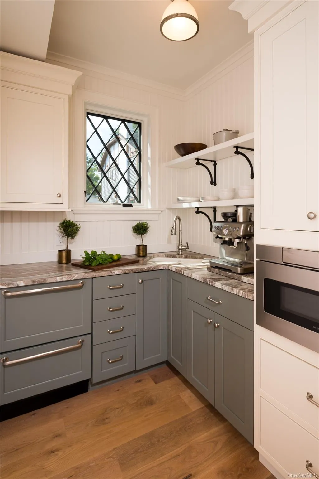 Kitchen with gray cabinets, white cabinetry, open shelves, ornamental molding, and light wood-style flooring Kitchen with gray cabinets, white cabinetry, open shelves, ornamental molding, and light wood-style flooring
