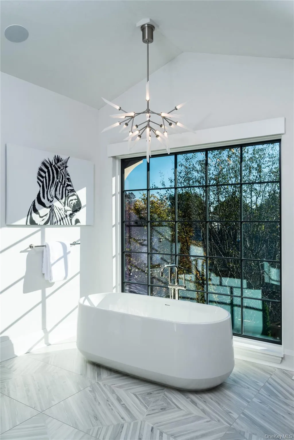 Full bath featuring a freestanding bath, a chandelier, and lofted ceiling Full bath featuring a freestanding bath, a chandelier, and lofted ceiling