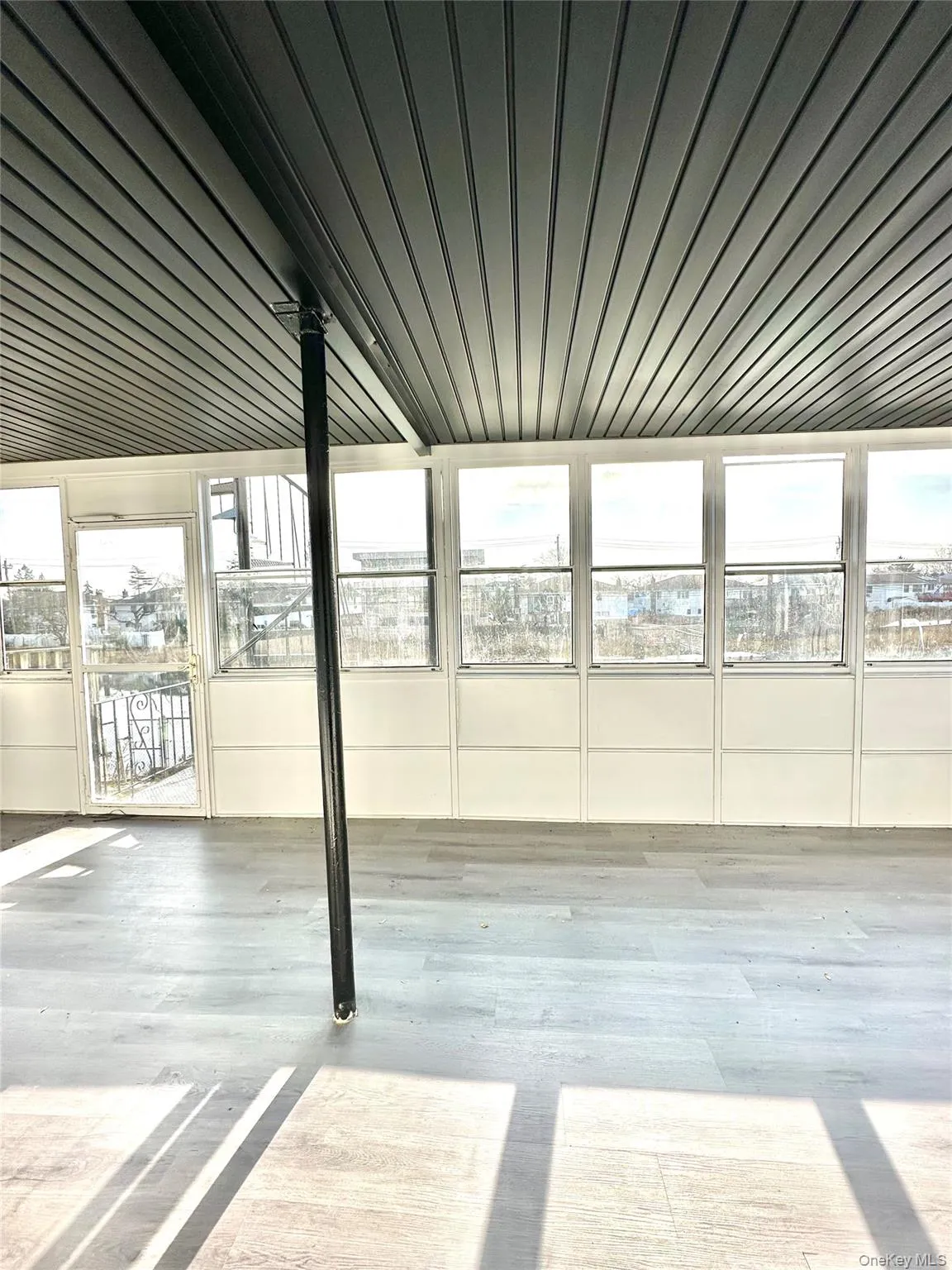 Unfurnished sunroom featuring wood ceiling and wood finished floors Unfurnished sunroom featuring wood ceiling and wood finished floors