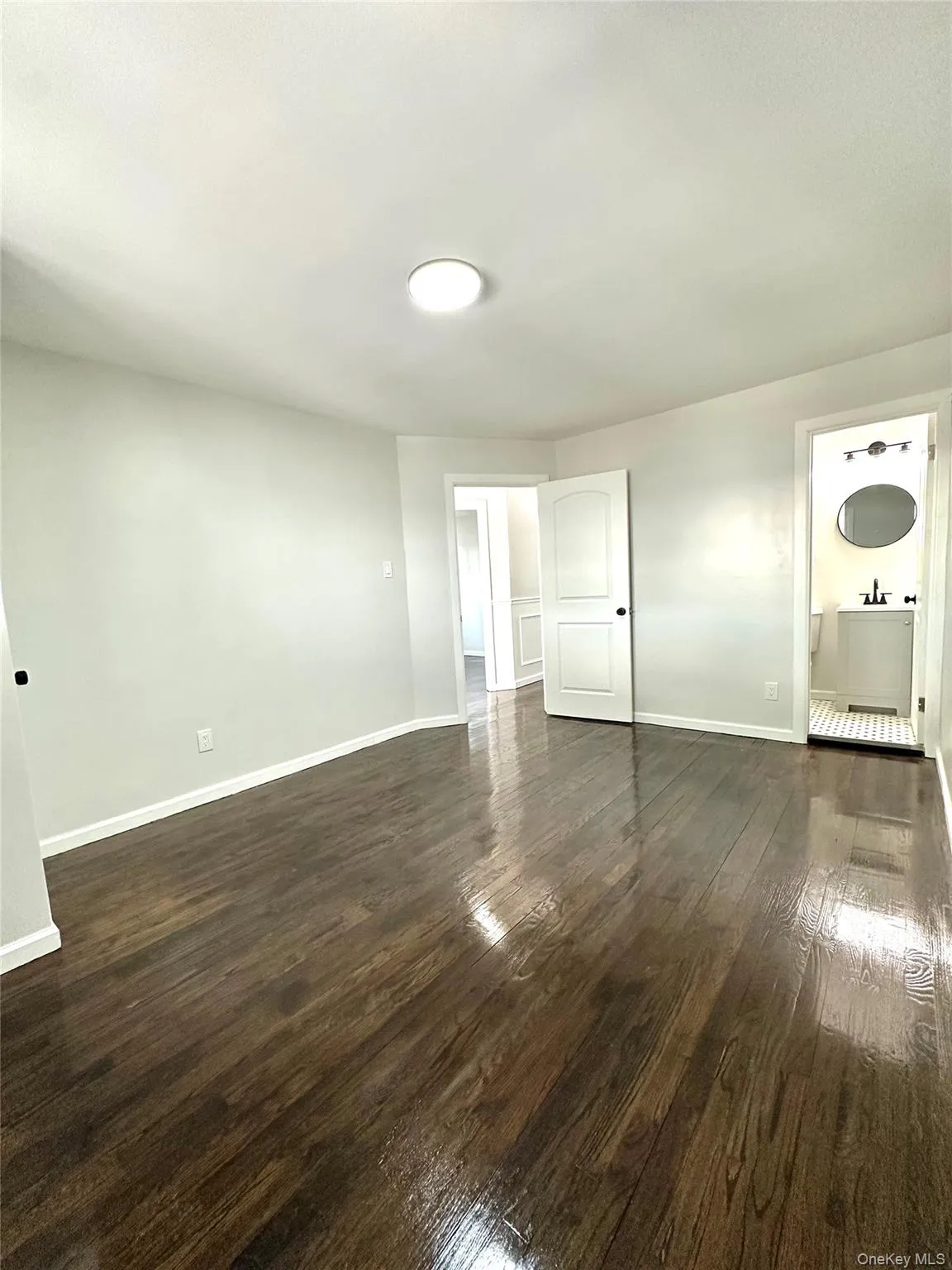 Unfurnished living room with baseboards and dark wood-style flooring Unfurnished living room with baseboards and dark wood-style flooring