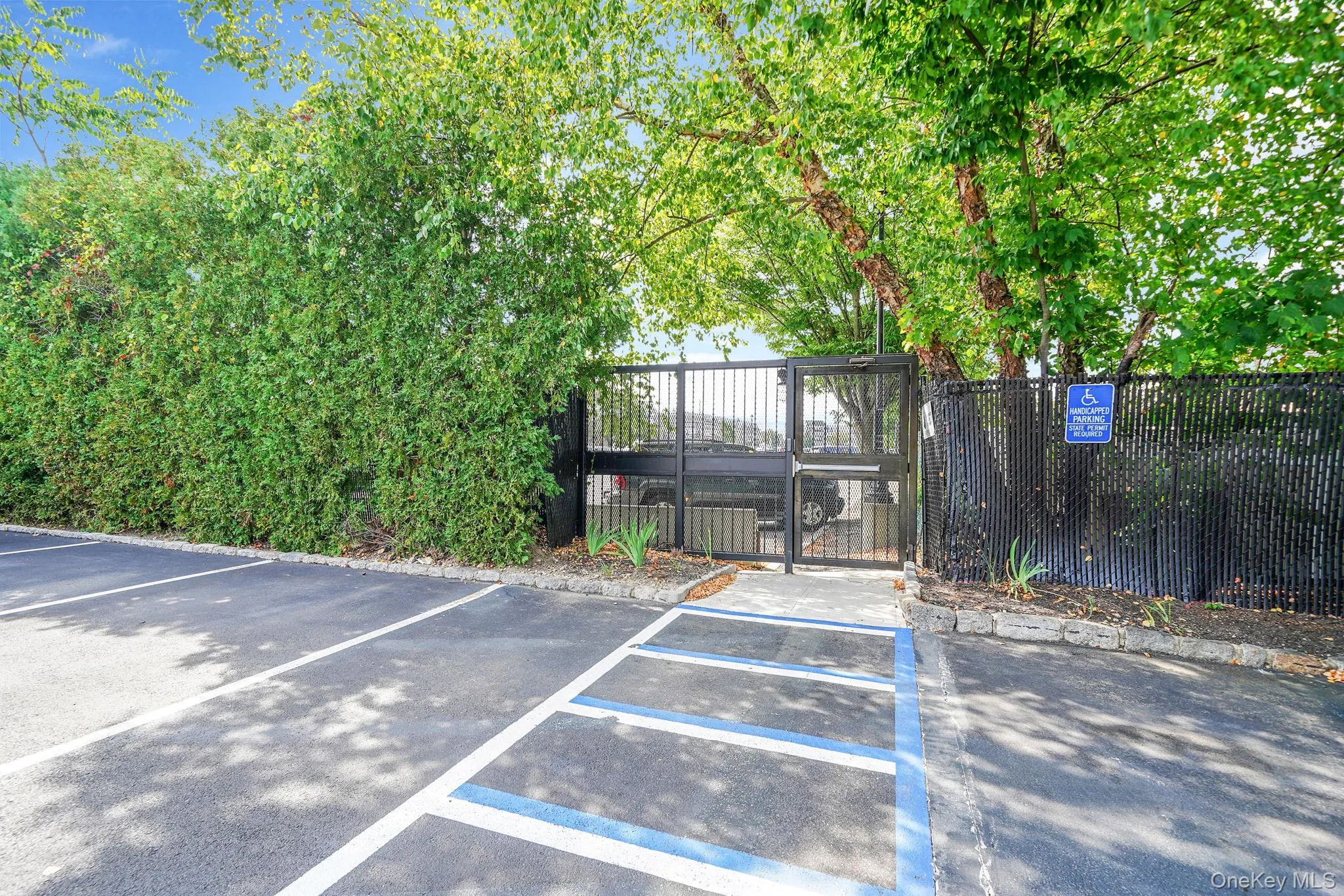 Uncovered parking lot featuring a gate Uncovered parking lot featuring a gate