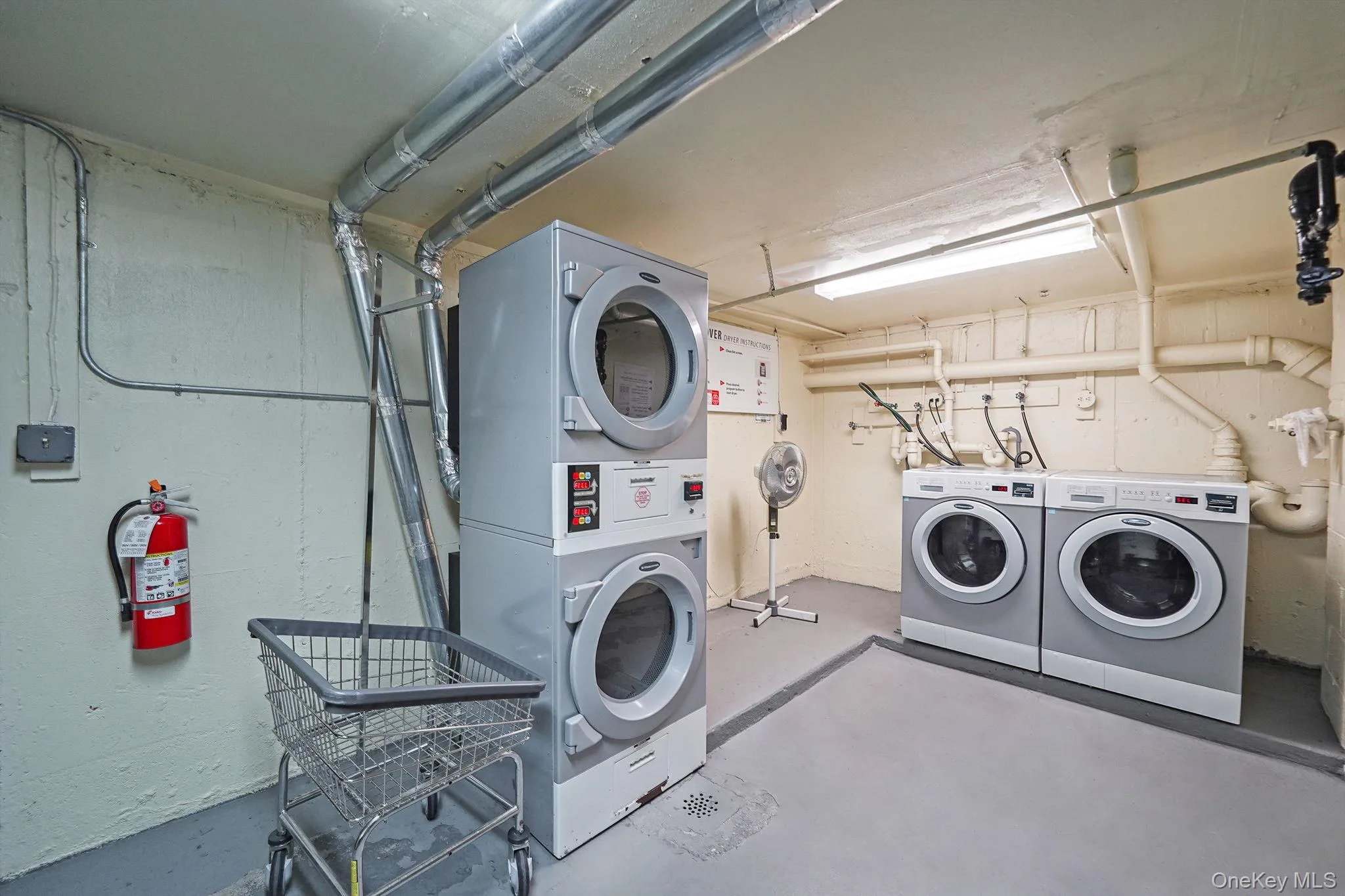 Community laundry room featuring stacked washer and clothes dryer Community laundry room featuring stacked washer and clothes dryer