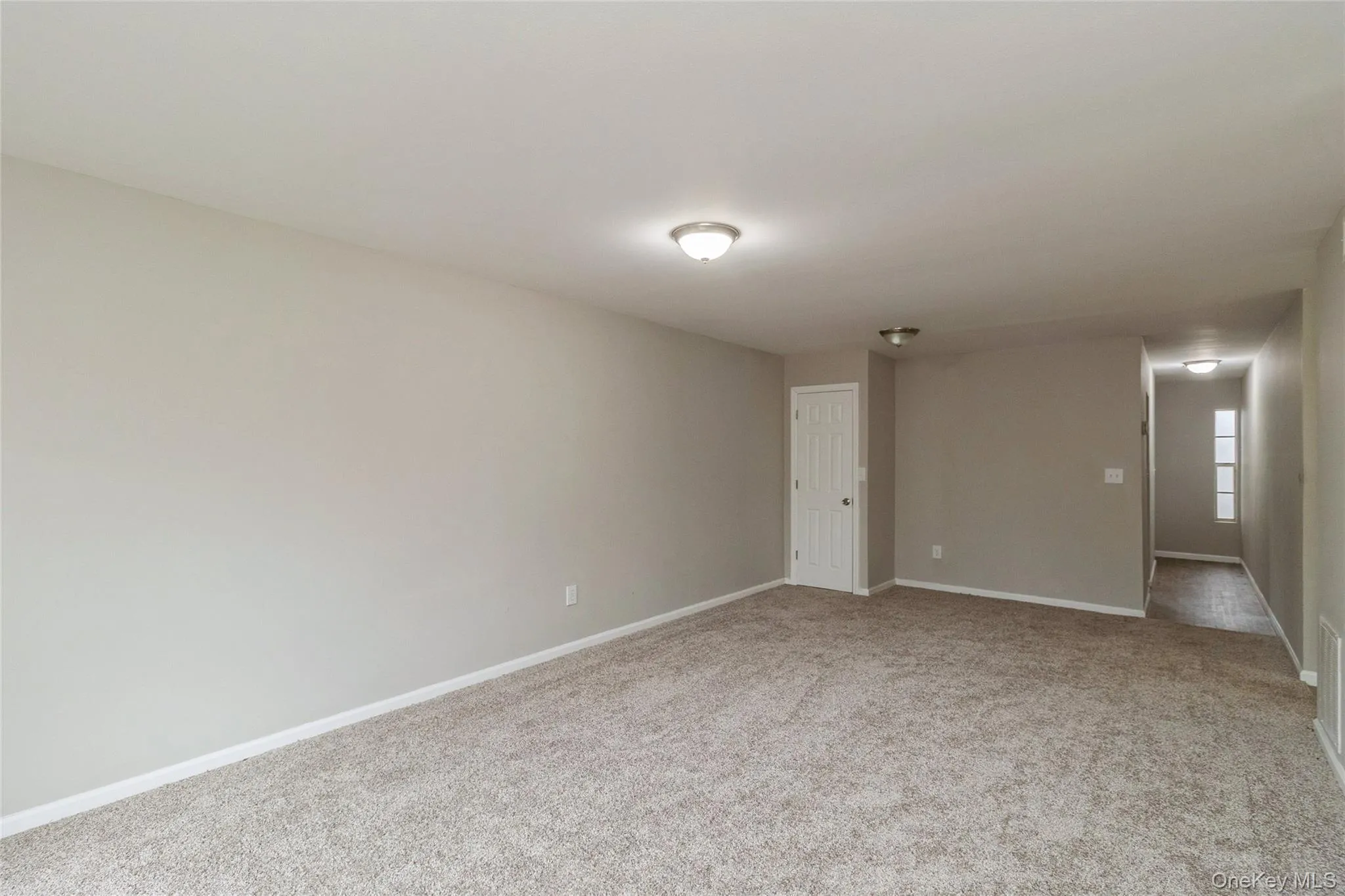Spare room featuring baseboards and light colored carpet Spare room featuring baseboards and light colored carpet