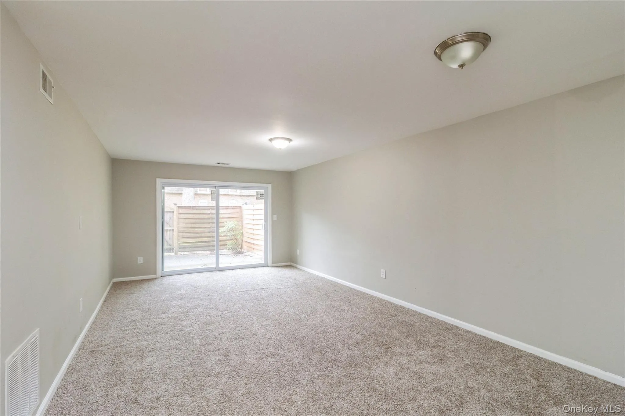 Empty room with carpet floors and baseboards Empty room with carpet floors and baseboards