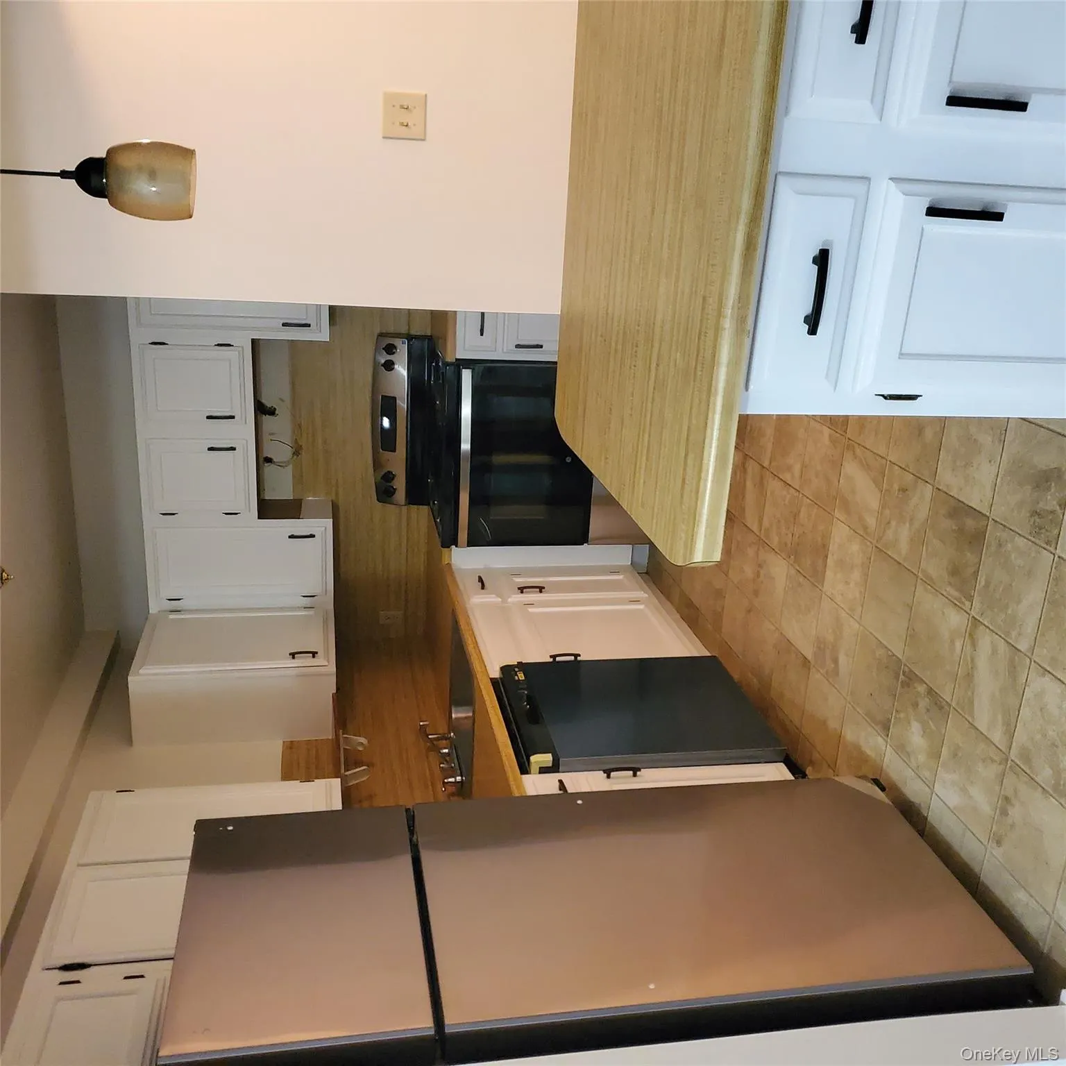 Kitchen with refrigerator, white cabinets, stainless steel range, and light countertops Kitchen with refrigerator, white cabinets, stainless steel range, and light countertops