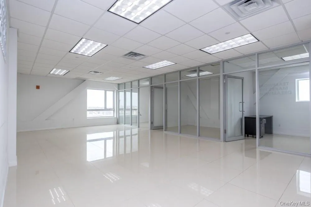 Empty room with light tile patterned flooring and a drop ceiling Empty room with light tile patterned flooring and a drop ceiling