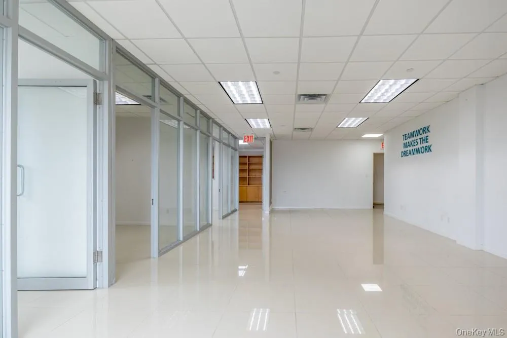 Empty room with a drop ceiling and light tile patterned flooring Empty room with a drop ceiling and light tile patterned flooring