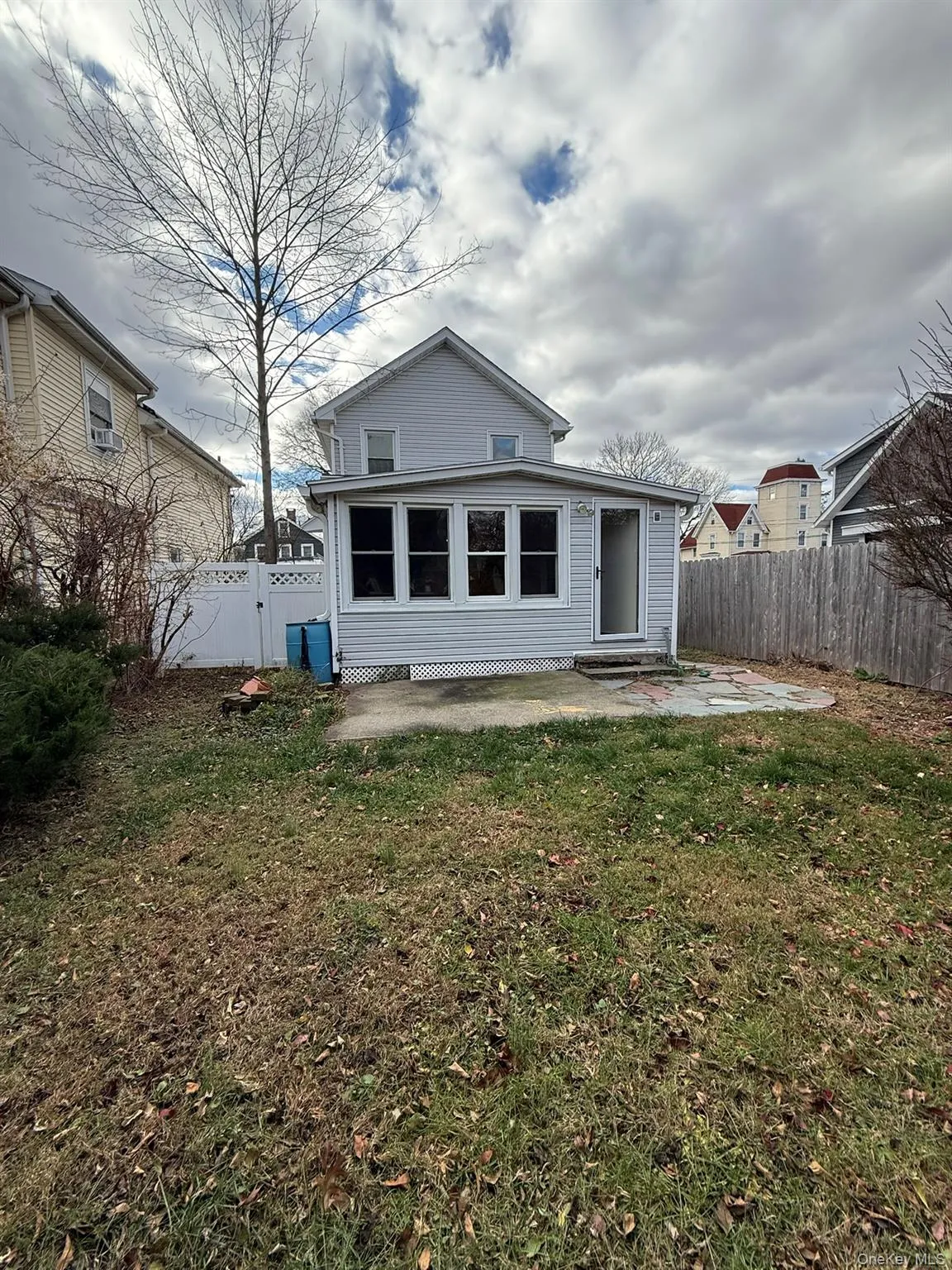 Back of house with a patio area, a fenced backyard, a gate, and a sunroom Back of house with a patio area, a fenced backyard, a gate, and a sunroom