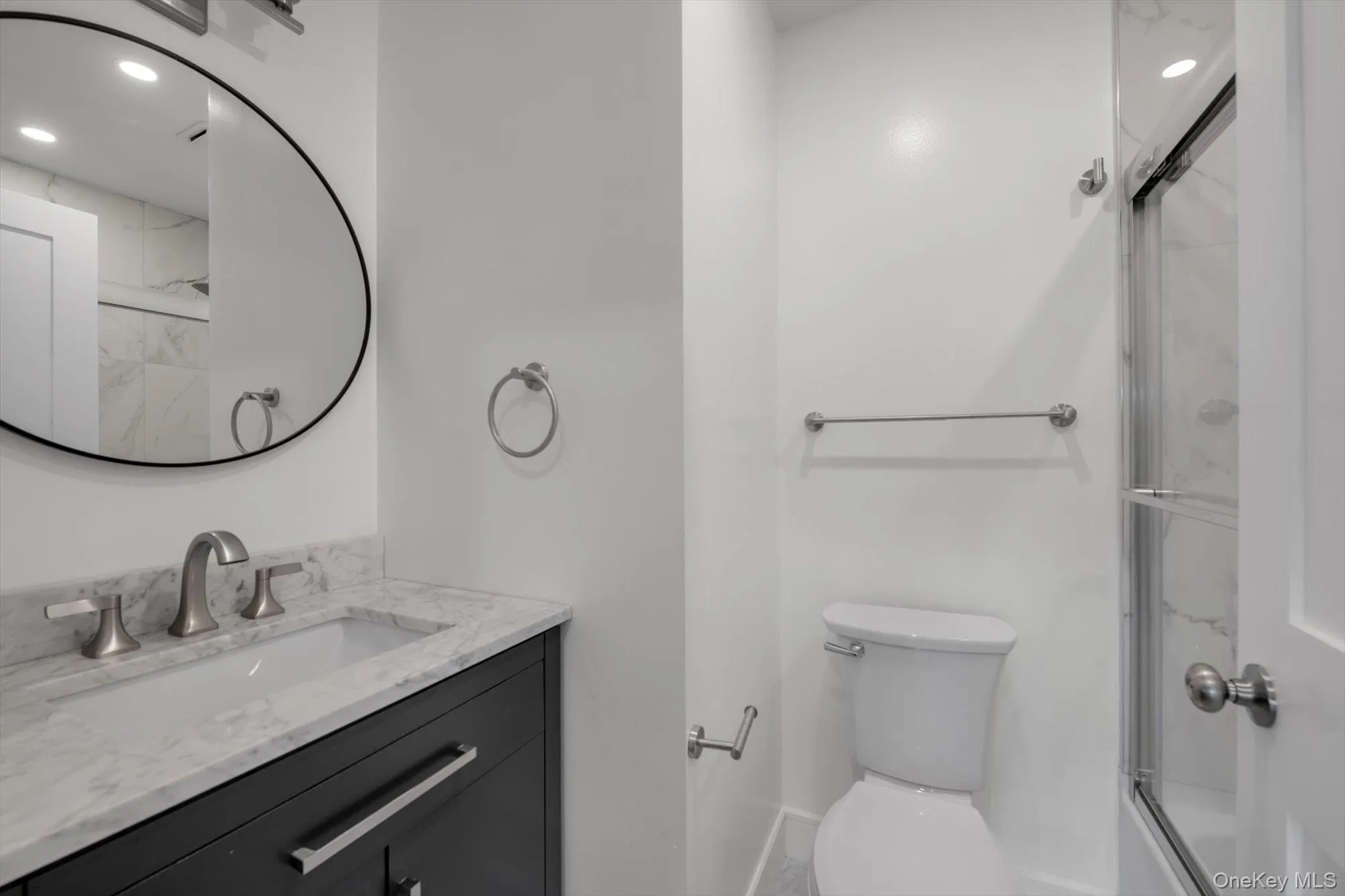 Full bath featuring vanity, recessed lighting, and enclosed tub / shower combo Full bath featuring vanity, recessed lighting, and enclosed tub / shower combo