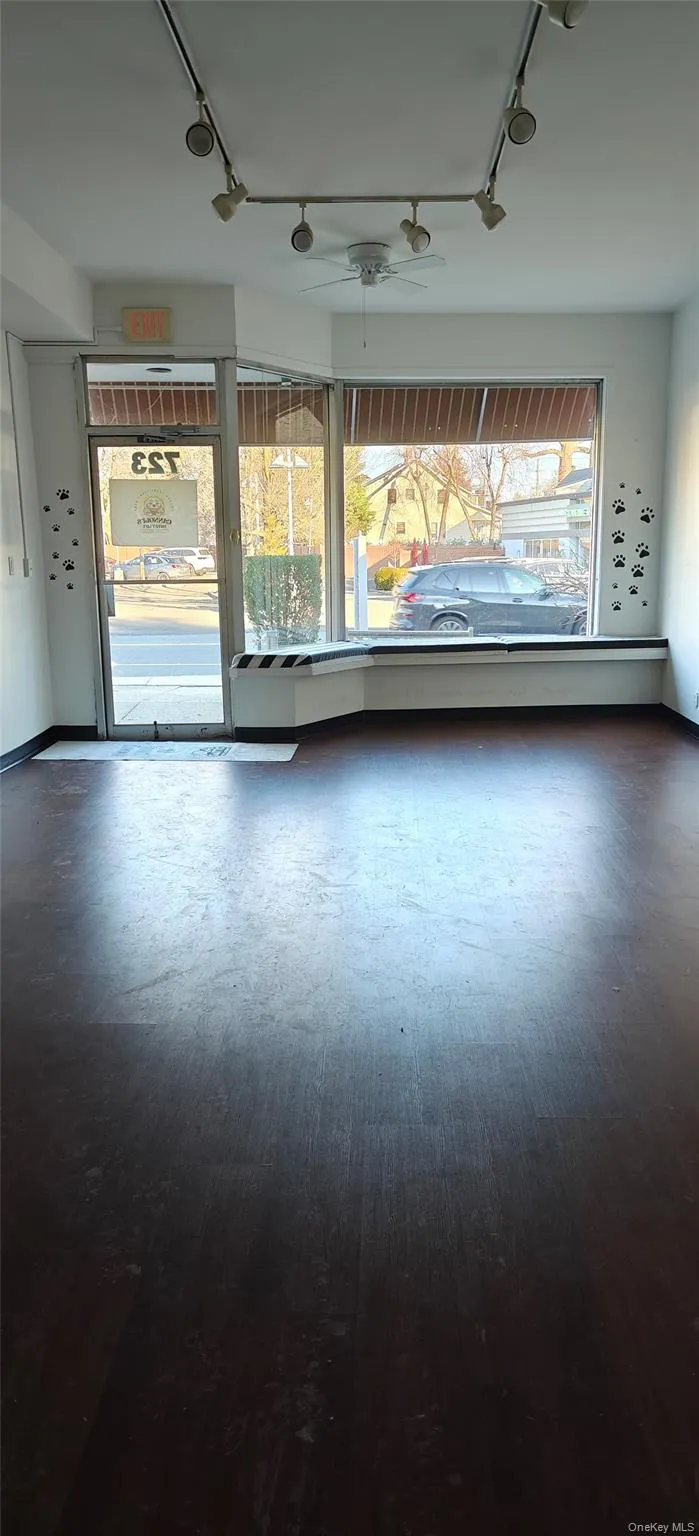 A spacious main room featuring a large display window and track lighting. A spacious main room featuring a large display window and track lighting.