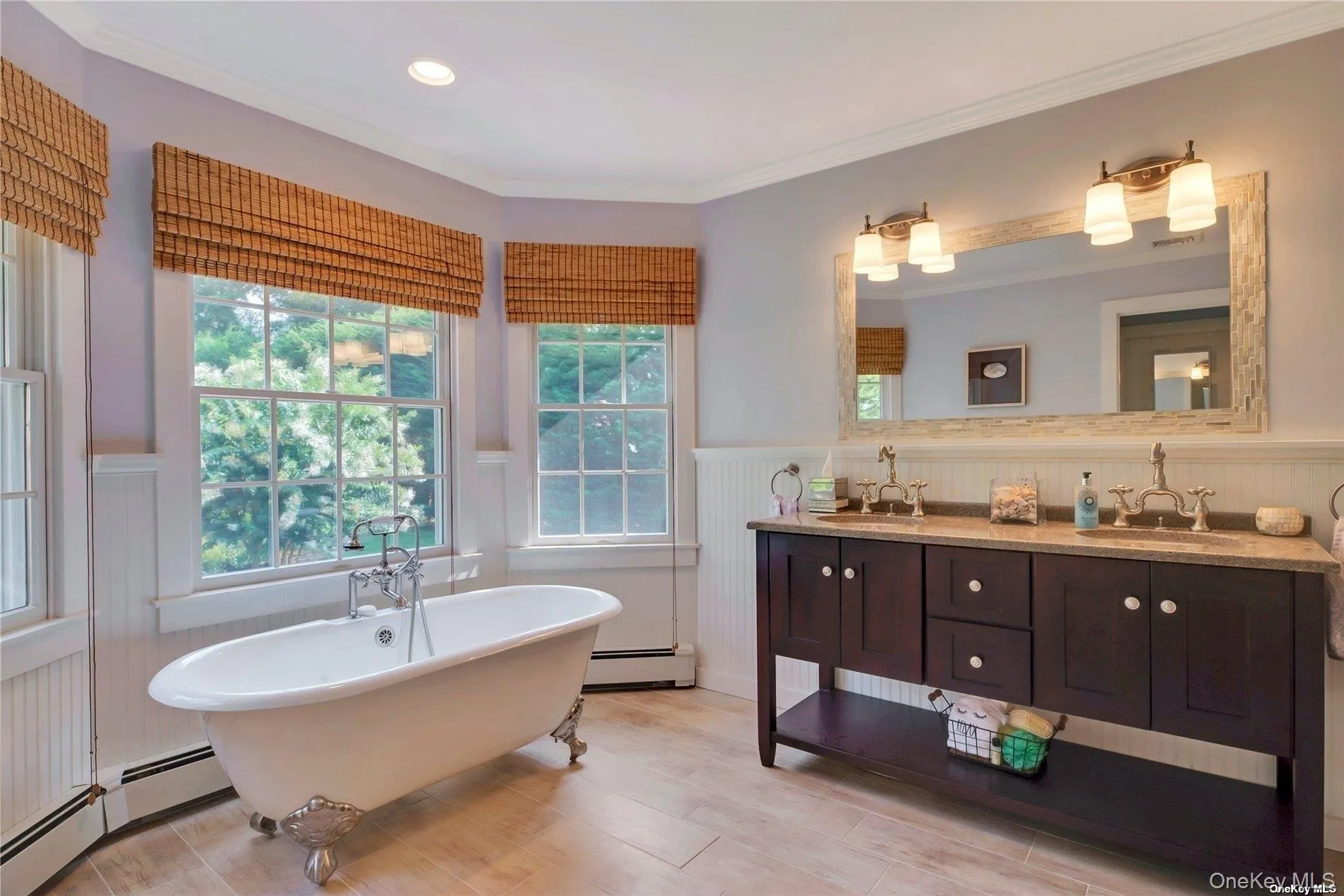 Primary bath with soaking tub, double vanity and view of rear yard Primary bath with soaking tub, double vanity and view of rear yard