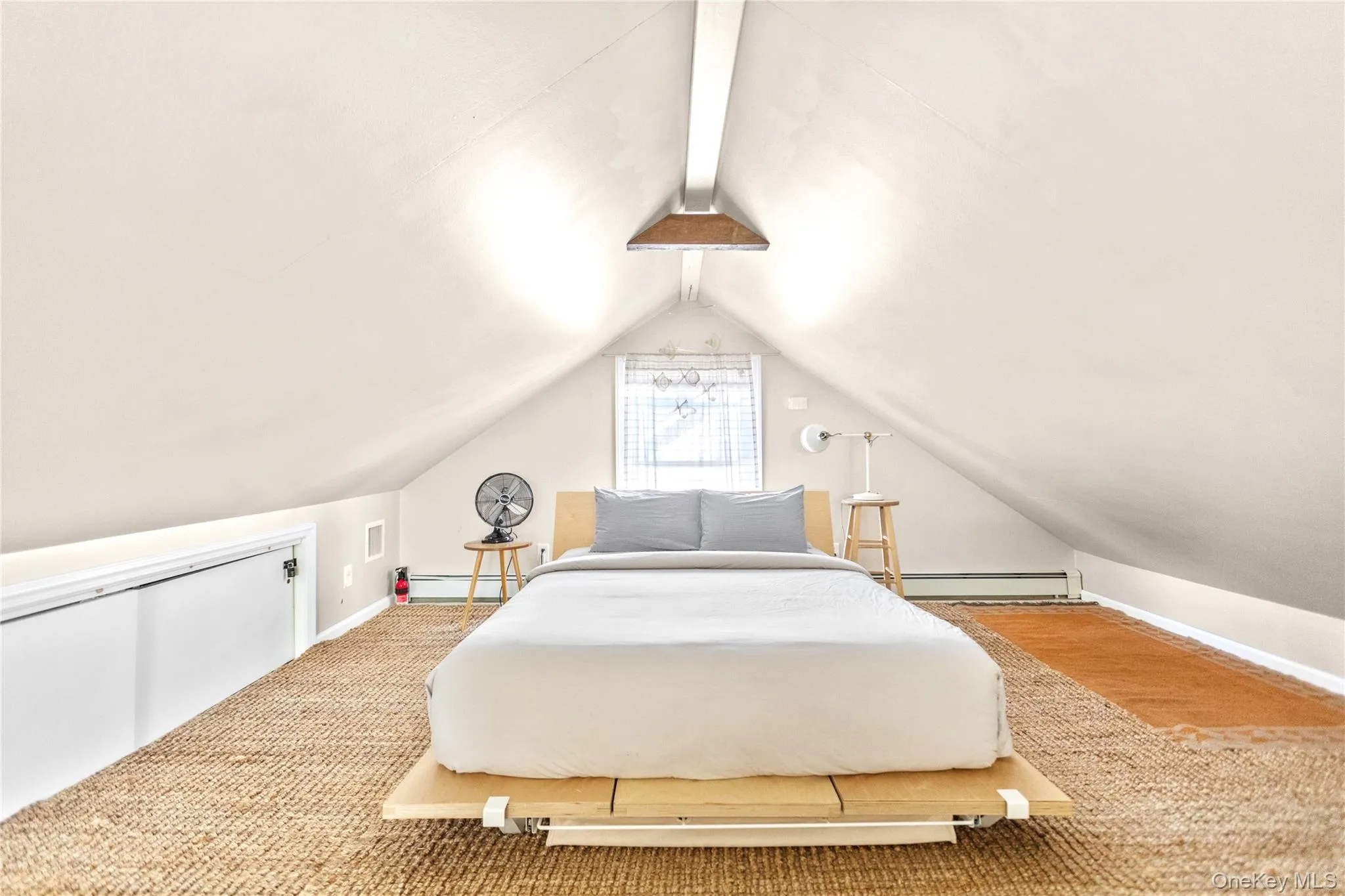 Bedroom featuring lofted ceiling and baseboard heating Bedroom featuring lofted ceiling and baseboard heating