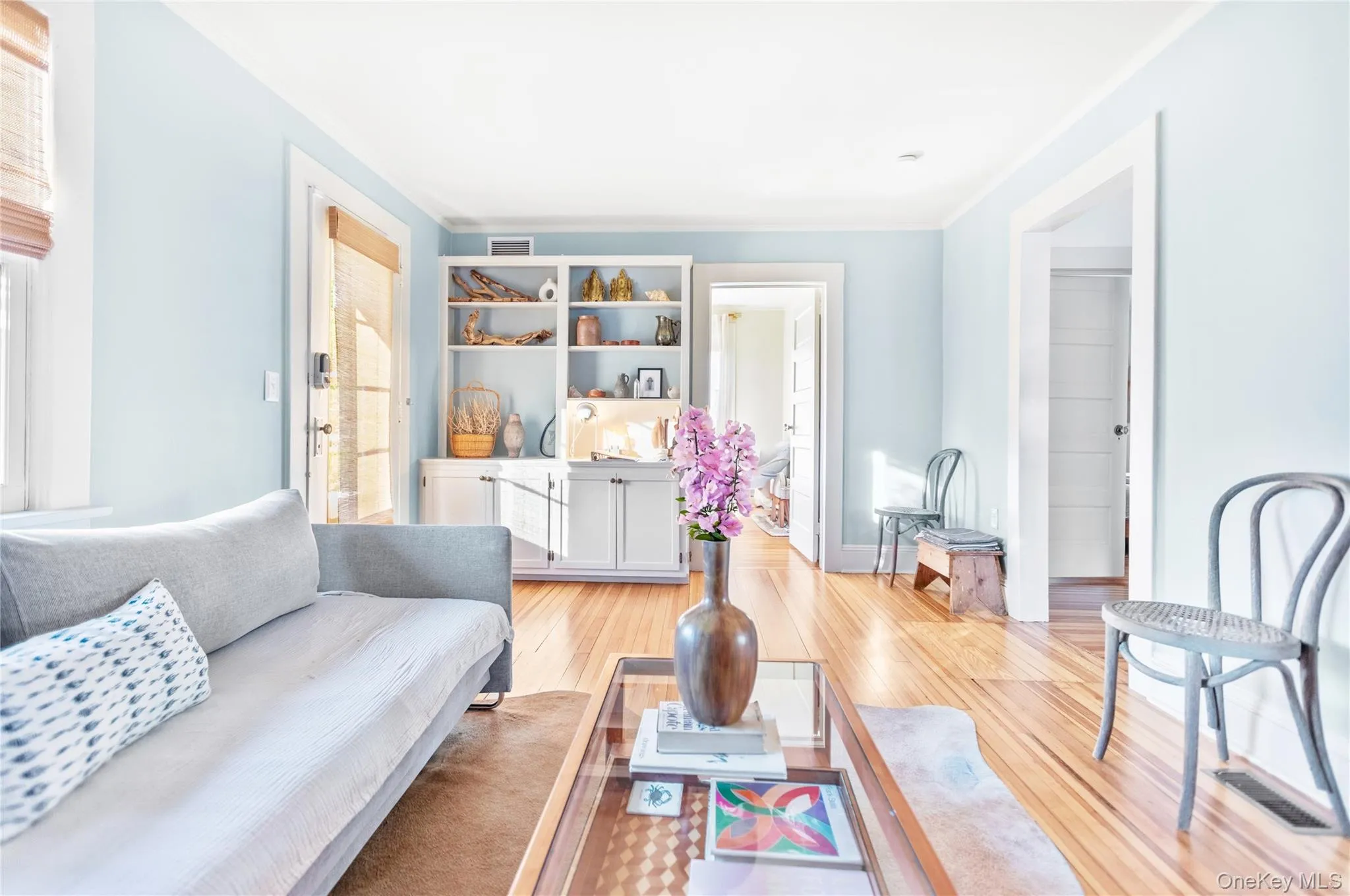 Living room with light wood-style floors and ornamental molding Living room with light wood-style floors and ornamental molding