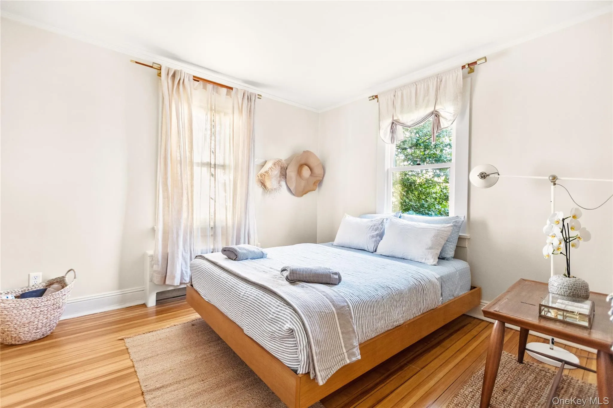 Bedroom with ornamental molding and wood finished floors Bedroom with ornamental molding and wood finished floors