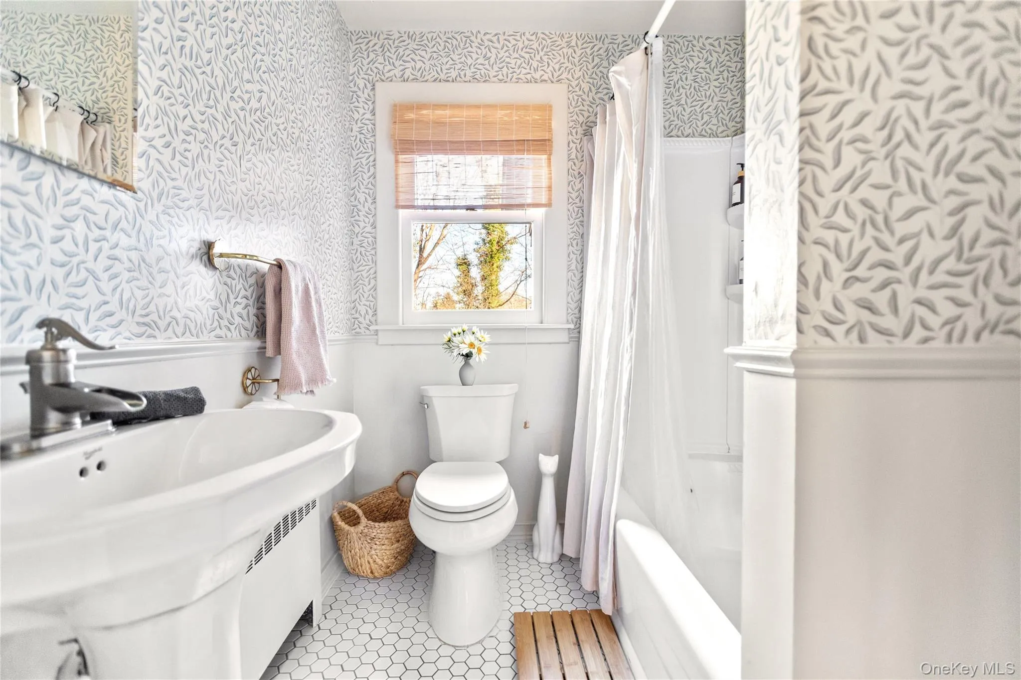 Bathroom with wallpapered walls, wainscoting, shower / bathtub combination with curtain, and light tile patterned flooring Bathroom with wallpapered walls, wainscoting, shower / bathtub combination with curtain, and light tile patterned flooring