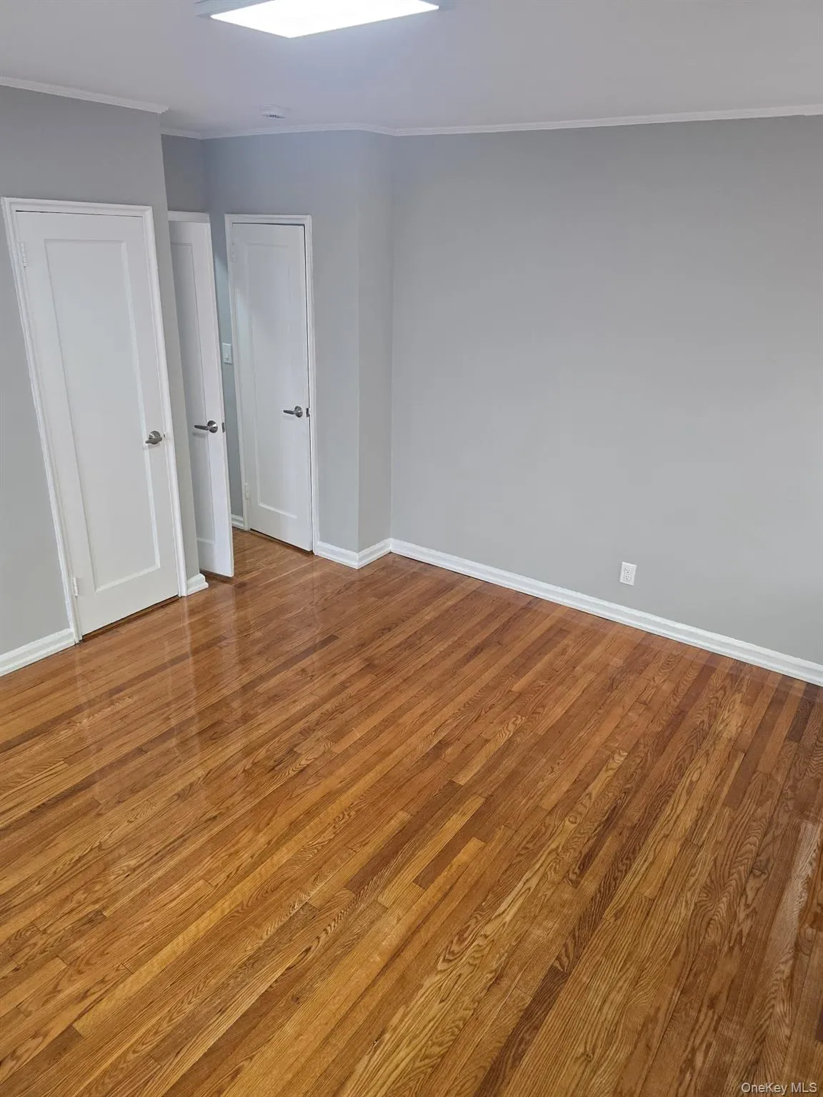 Unfurnished bedroom featuring light wood-style floors and crown molding Unfurnished bedroom featuring light wood-style floors and crown molding