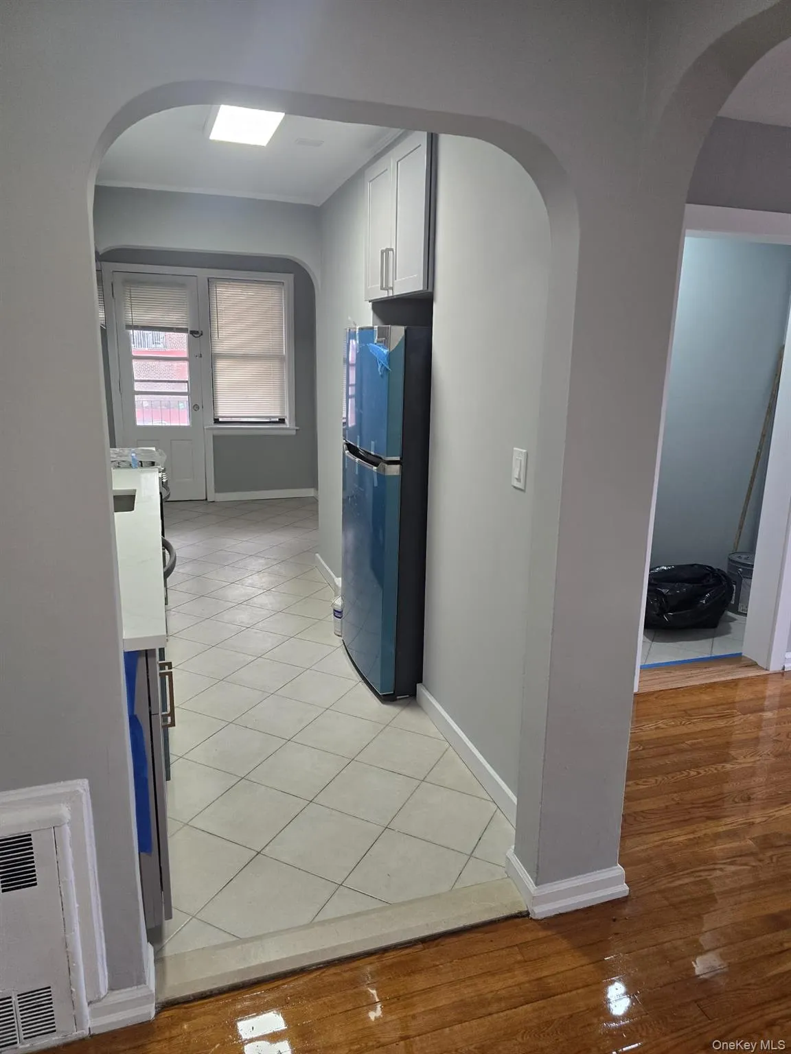 Corridor featuring arched walkways and light wood-type flooring Corridor featuring arched walkways and light wood-type flooring