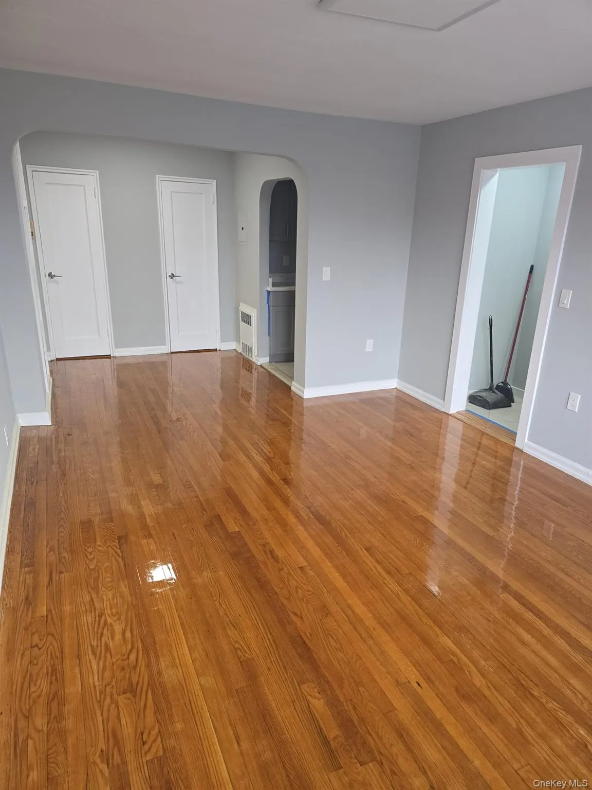 Spare room featuring arched walkways and light wood-type flooring Spare room featuring arched walkways and light wood-type flooring