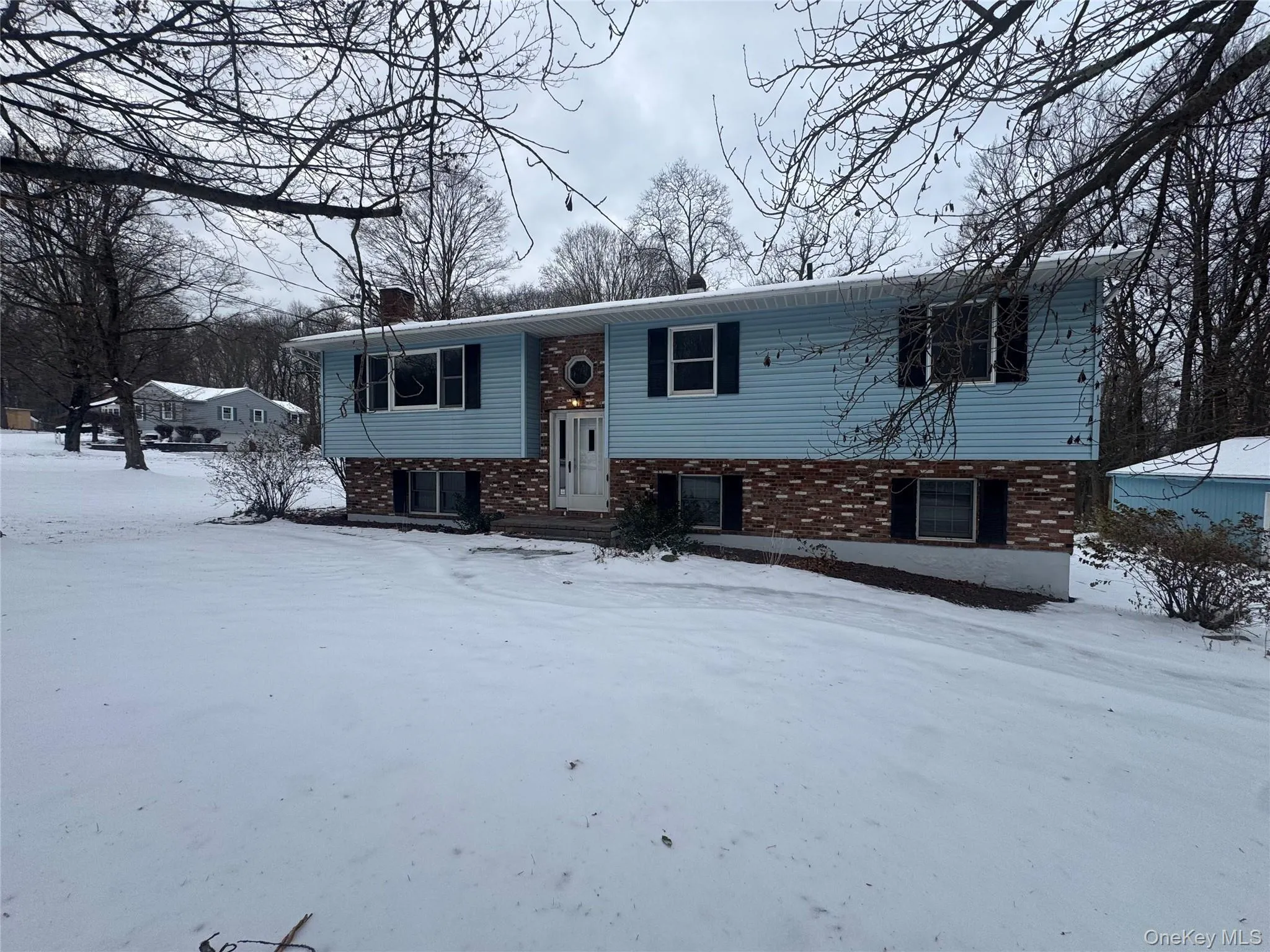Split foyer home featuring brick siding and a chimney Split foyer home featuring brick siding and a chimney