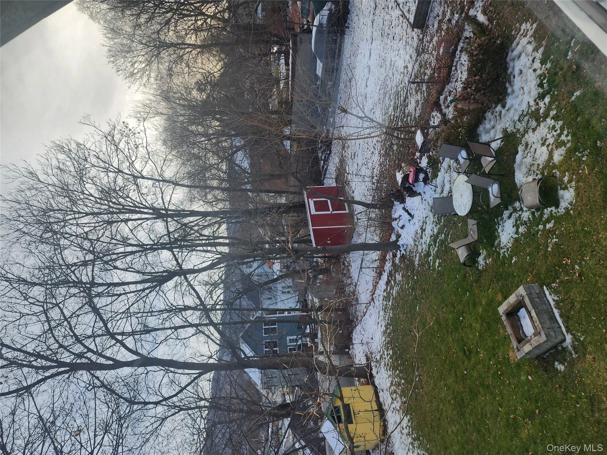 Yard layered in snow with an outdoor fire pit, a yard, and a storage unit Yard layered in snow with an outdoor fire pit, a yard, and a storage unit