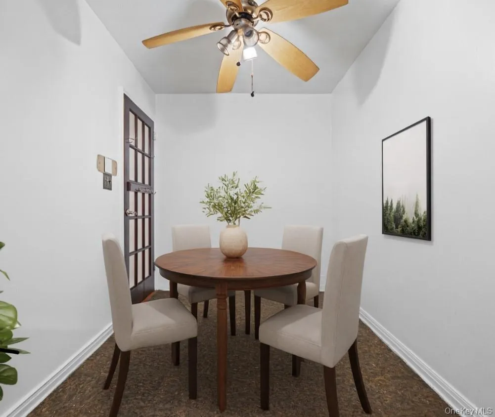 Carpeted dining space featuring baseboards and a ceiling fan Carpeted dining space featuring baseboards and a ceiling fan