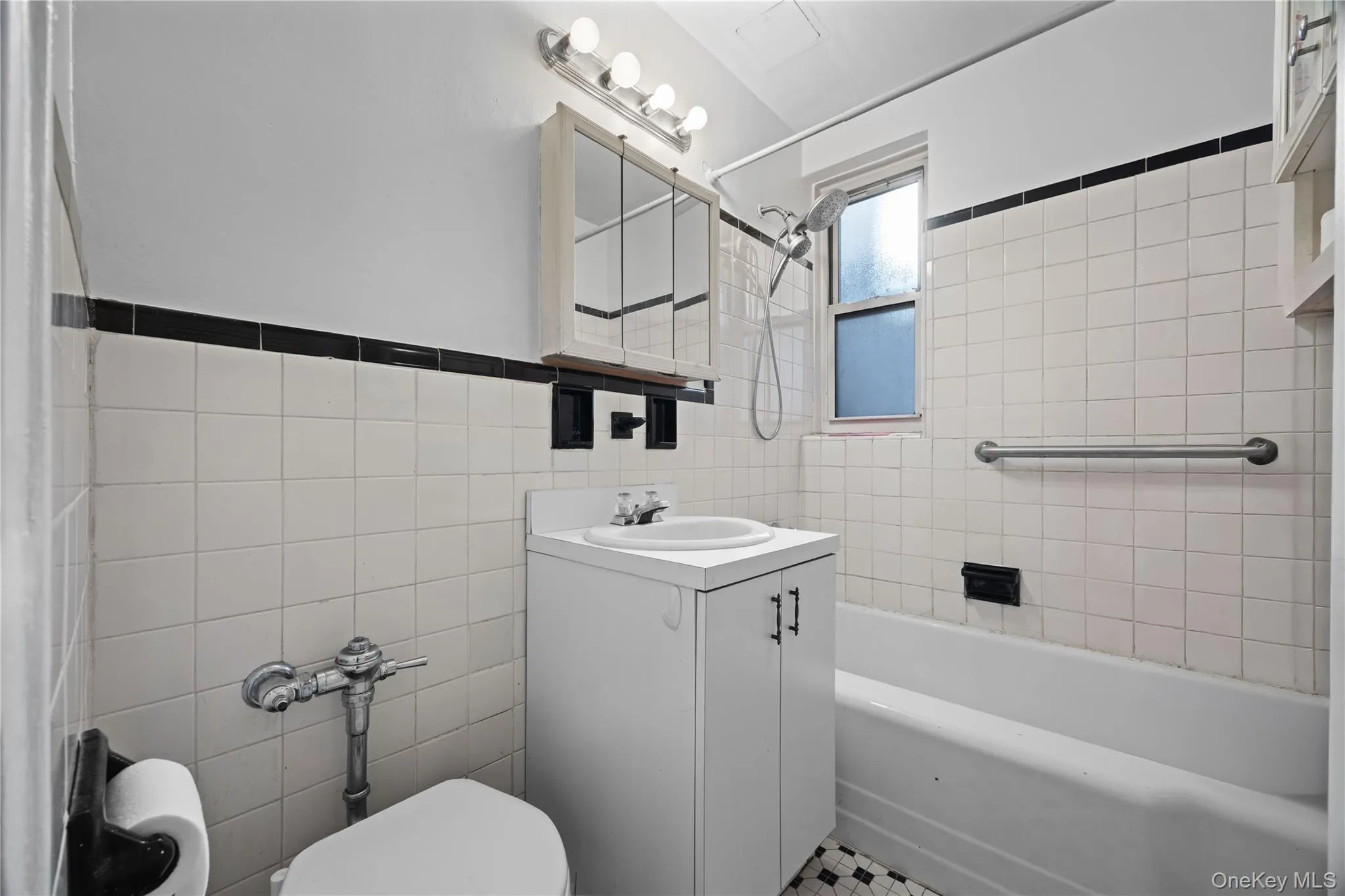 Full bath featuring vanity, bathtub / shower combination, and tile walls Full bath featuring vanity, bathtub / shower combination, and tile walls