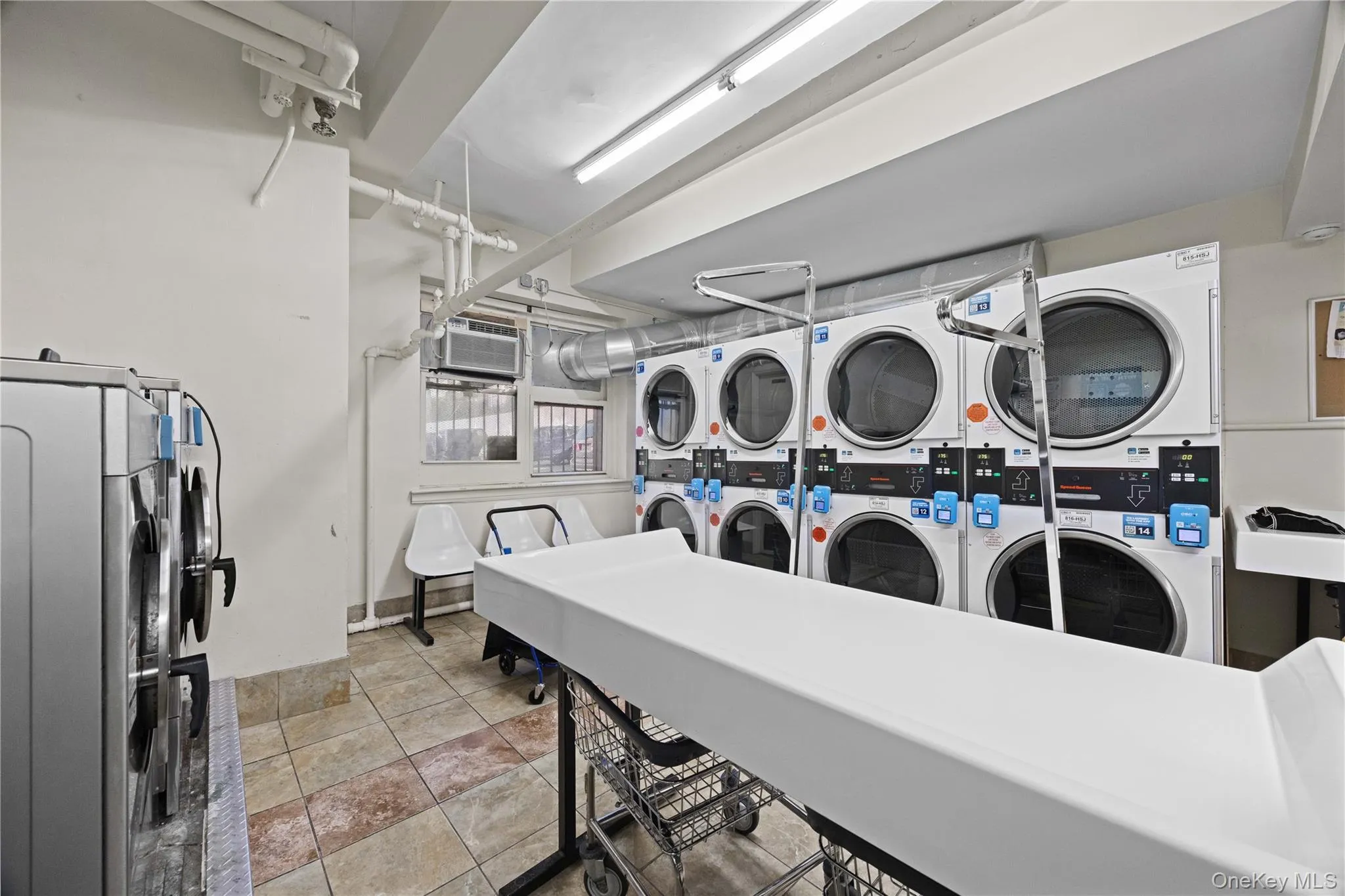 Communal laundry room featuring stacked washer / dryer Communal laundry room featuring stacked washer / dryer