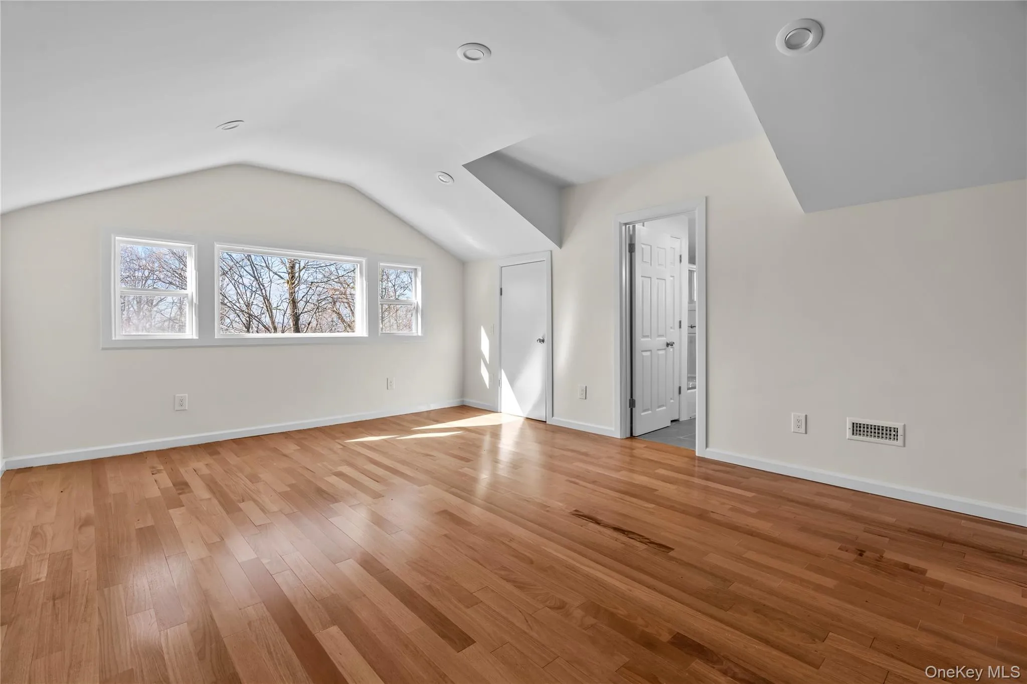 Additional living space featuring light wood-type flooring and vaulted ceiling Additional living space featuring light wood-type flooring and vaulted ceiling