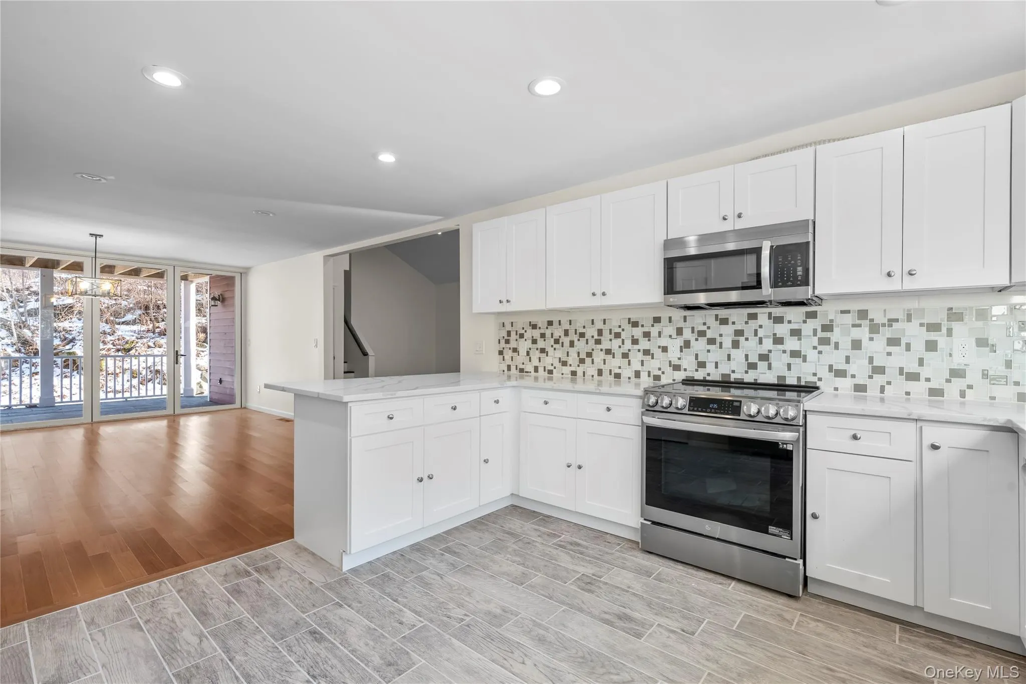 Kitchen with kitchen peninsula, white cabinets, and stainless steel appliances Kitchen with kitchen peninsula, white cabinets, and stainless steel appliances