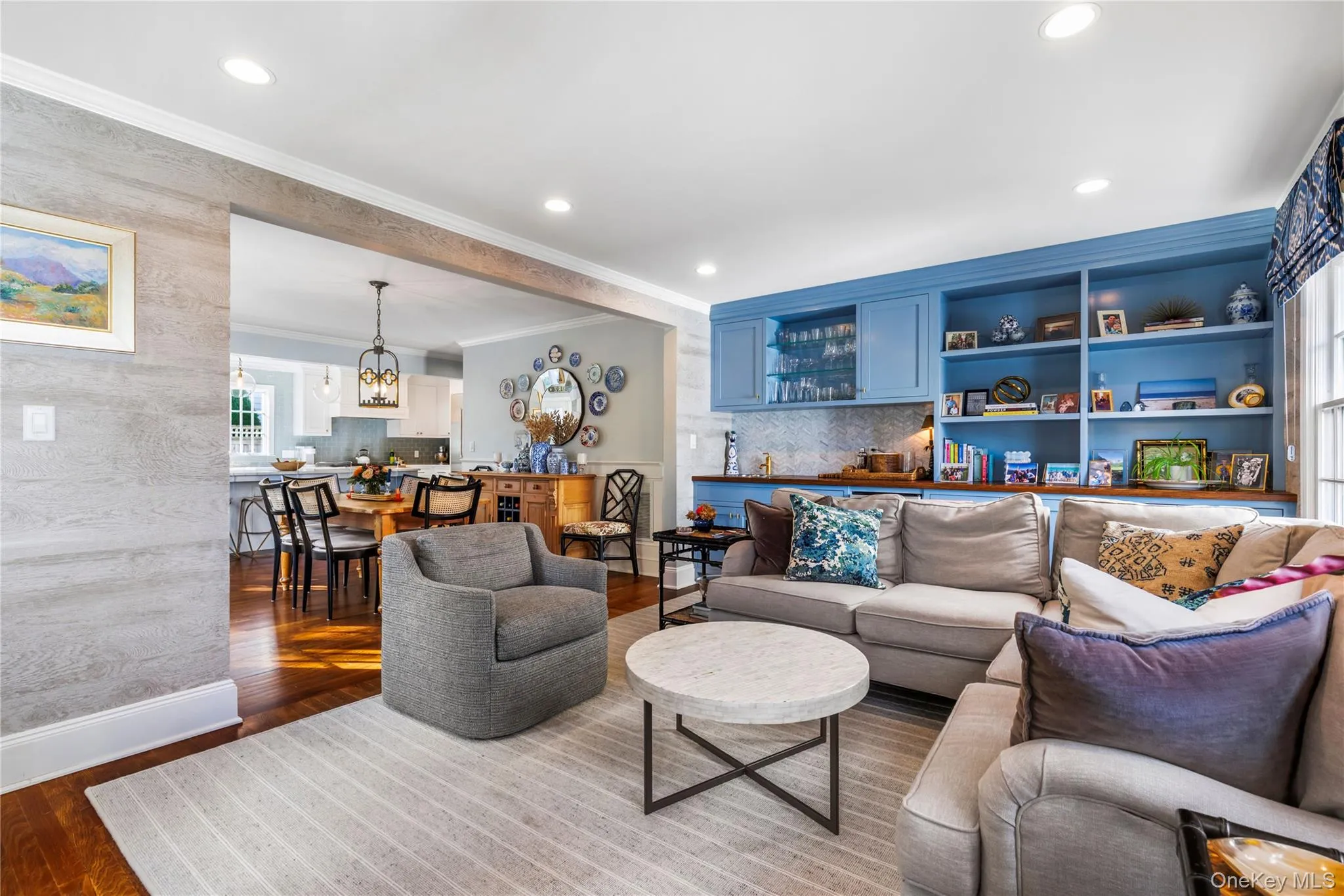 Living room featuring wood-type flooring, crown molding, a chandelier, and recessed lighting Living room featuring wood-type flooring, crown molding, a chandelier, and recessed lighting