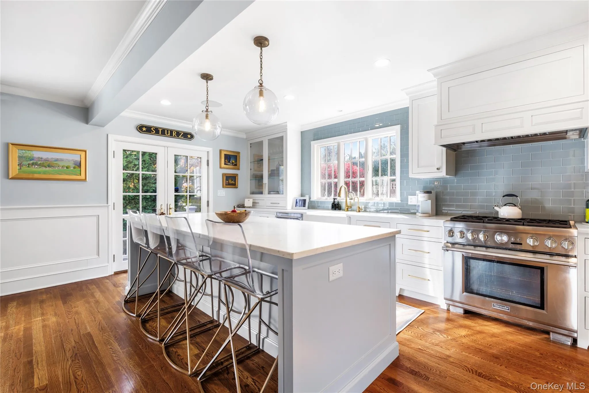 Kitchen featuring stainless steel stove, a kitchen island, with seating and pendant lighting Kitchen featuring stainless steel stove, a kitchen island, with seating and pendant lighting