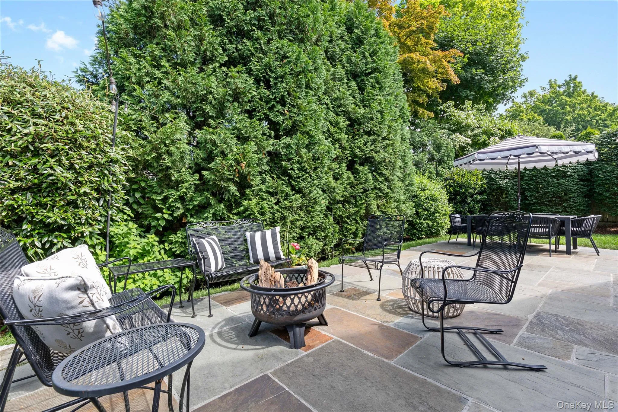 View of patio / terrace with an outdoor fire pit and outdoor dining area View of patio / terrace with an outdoor fire pit and outdoor dining area