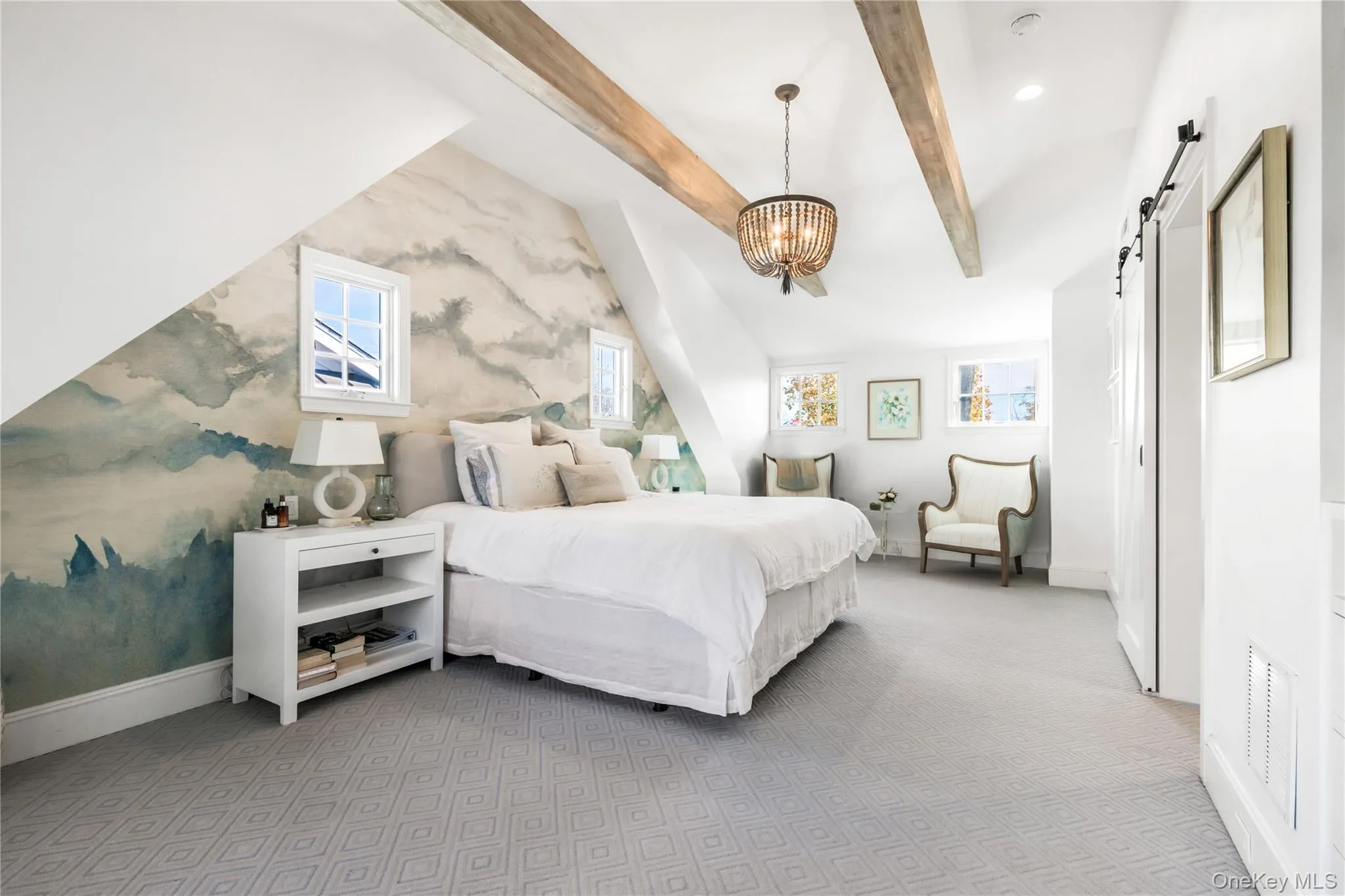 Primary bedroom with a barn door, beam ceiling, a chandelier, wall to wall carpet, walk in closet and full bath Primary bedroom with a barn door, beam ceiling, a chandelier, wall to wall carpet, walk in closet and full bath