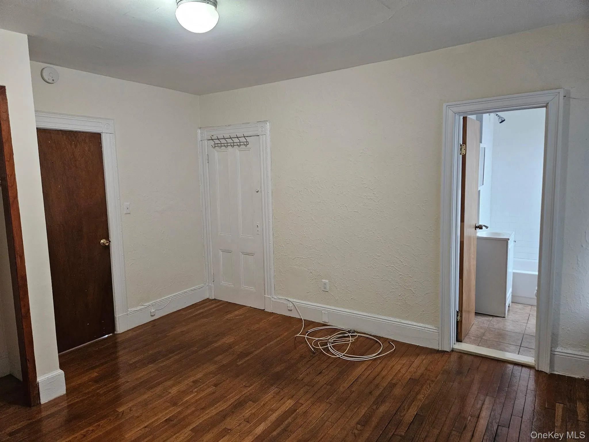 Unfurnished bedroom with baseboards and dark wood-type flooring Unfurnished bedroom with baseboards and dark wood-type flooring
