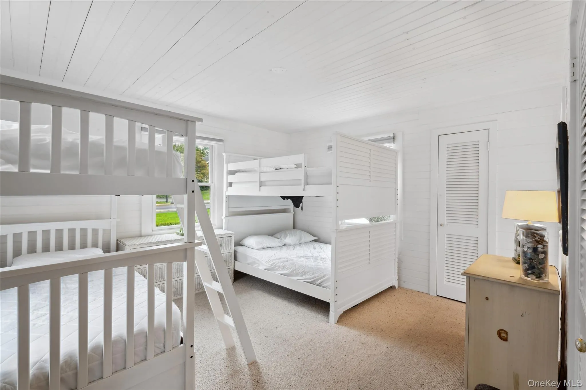 Bedroom featuring wooden ceiling, wood walls, and light colored carpet Bedroom featuring wooden ceiling, wood walls, and light colored carpet