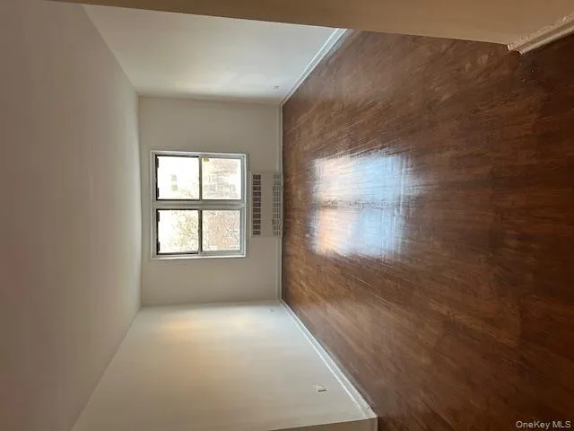 Empty room featuring radiator heating unit and dark wood finished floors Empty room featuring radiator heating unit and dark wood finished floors